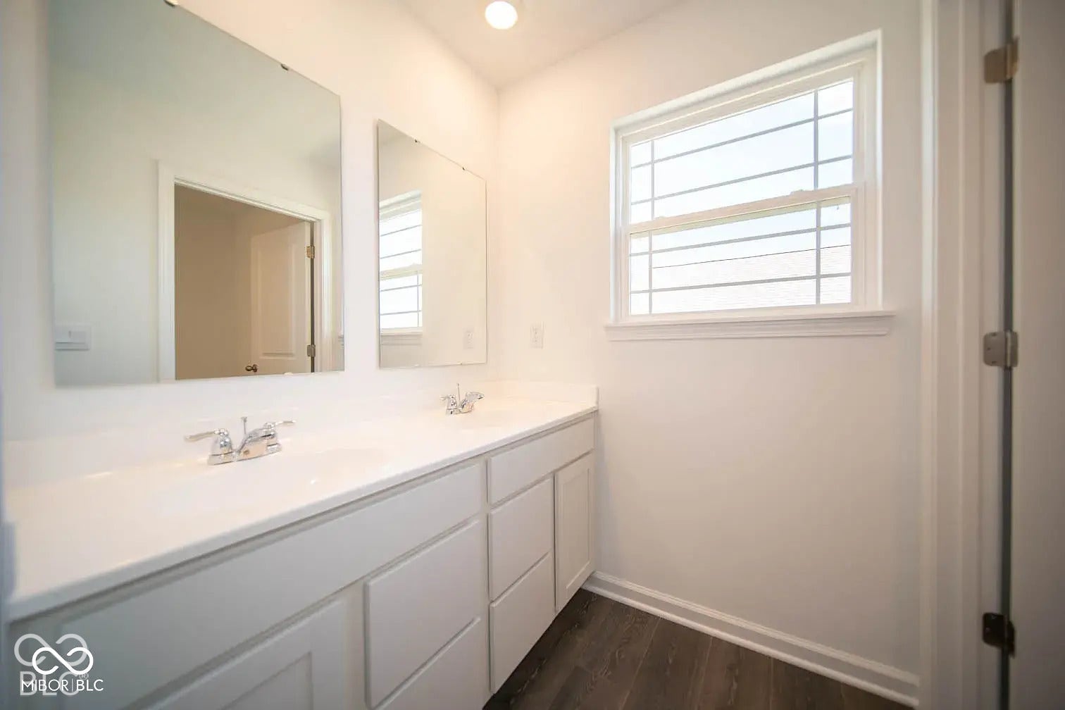 5778 Aleppo Lane, Greenwood, IN 46143 Dual vanity with white cabinetry, integrated sinks, chrome fixtures, and a large window