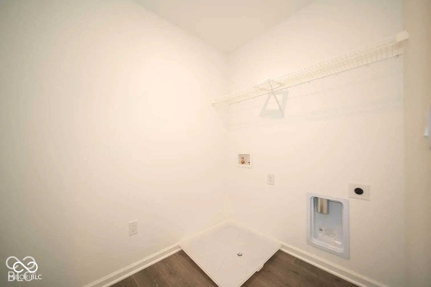 5778 Aleppo Lane, Greenwood, IN 46143 Laundry area featuring wood-finish flooring, white walls, and a white wire shelf