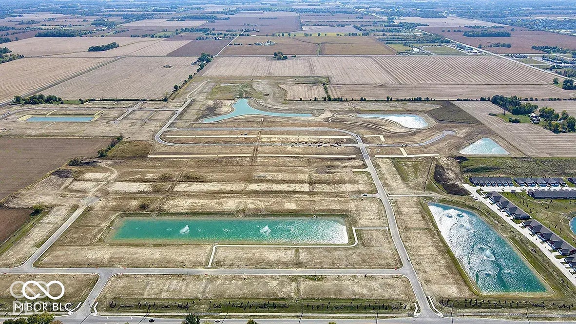 5778 Aleppo Lane, Greenwood, IN 46143 New development featuring multiple retention ponds with fountains, established residential structures, and paved road infrastructure