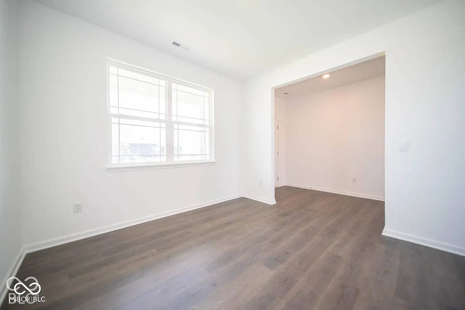 5778 Aleppo Lane, Greenwood, IN 46143 Hardwood-finish flooring, white walls, and a large window with white trim