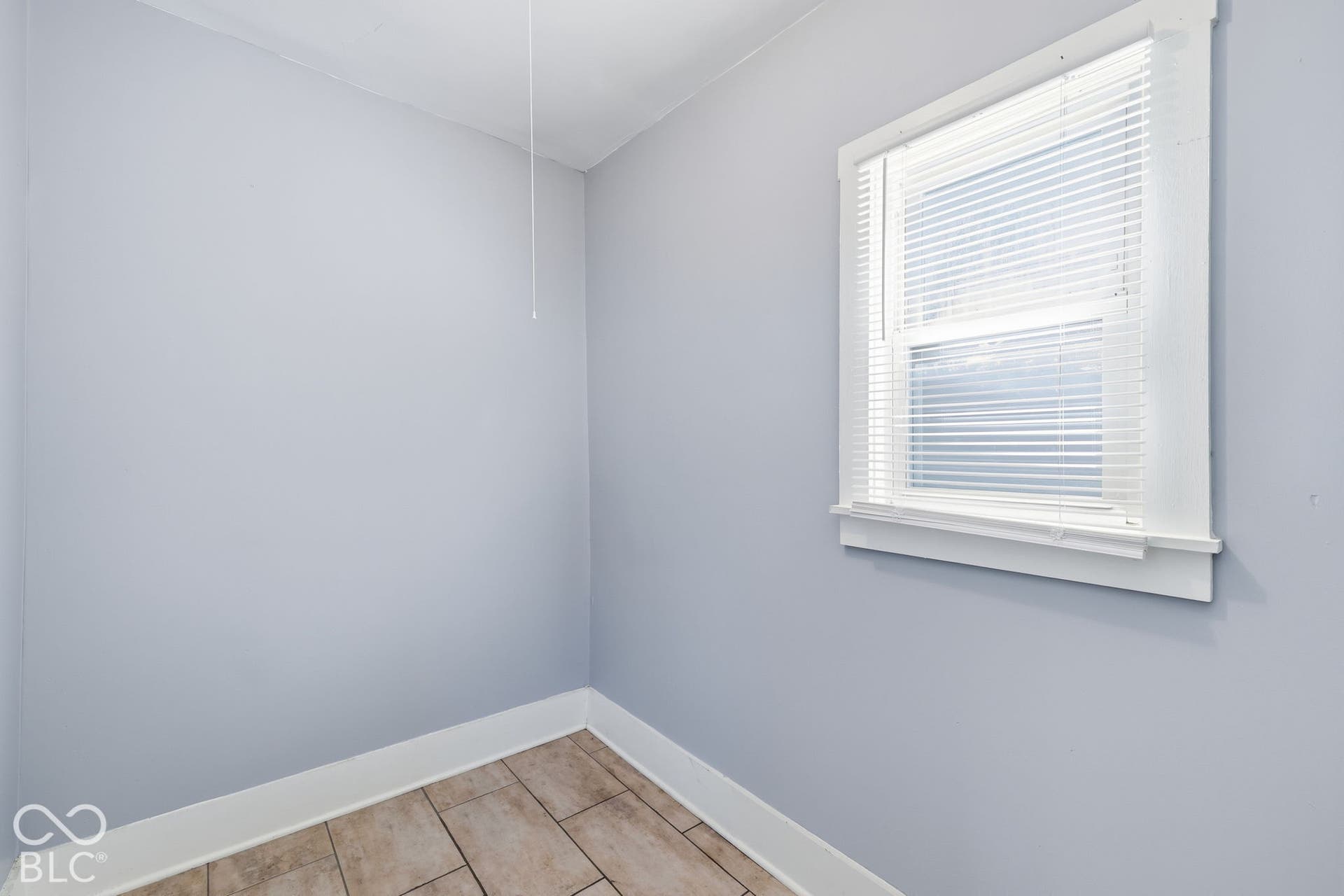 Light grey wall finish, white trim, and wood-look tile flooring