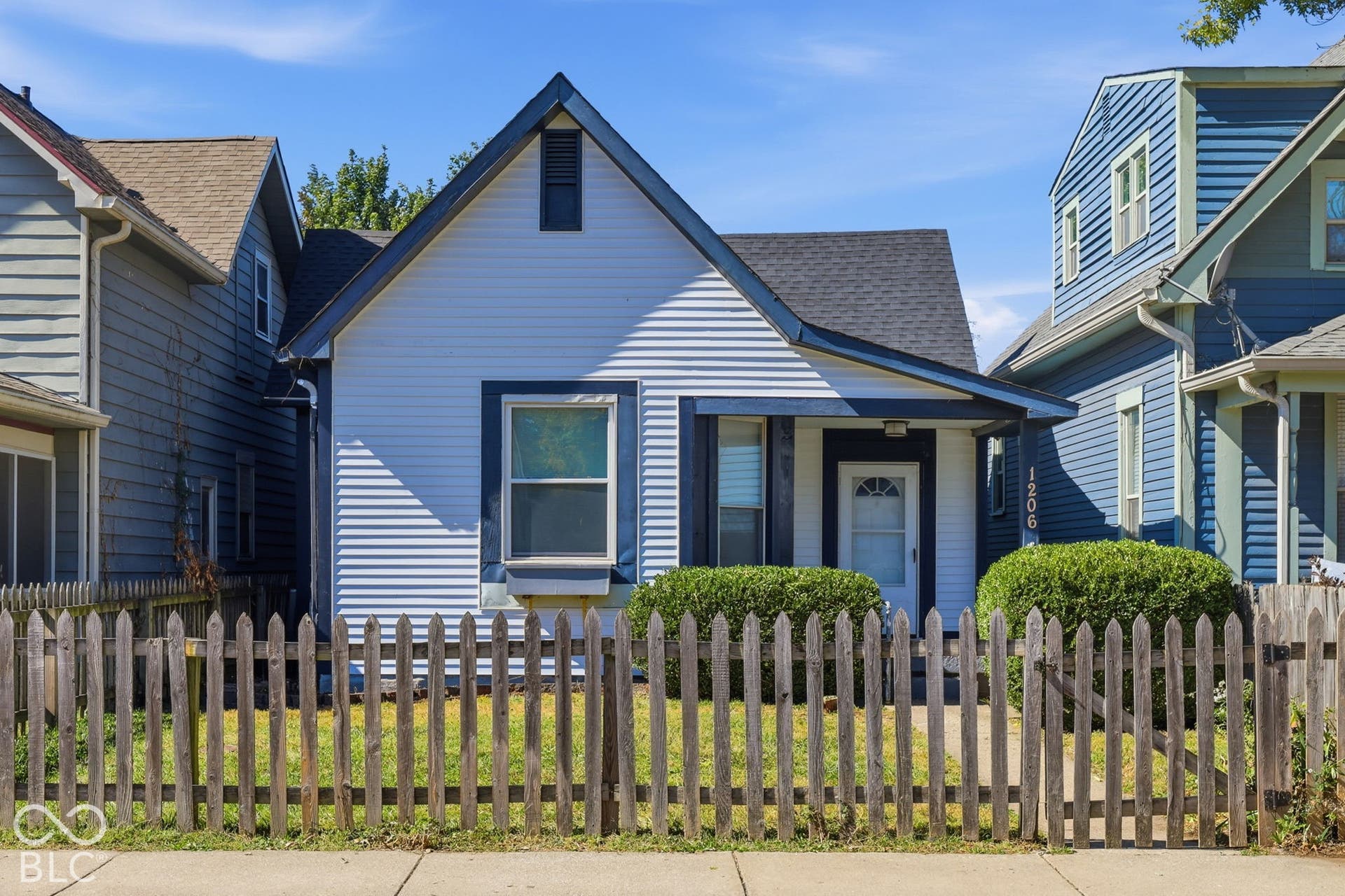 Gabled roofline with dark shingles, white horizontal siding, and dark trim