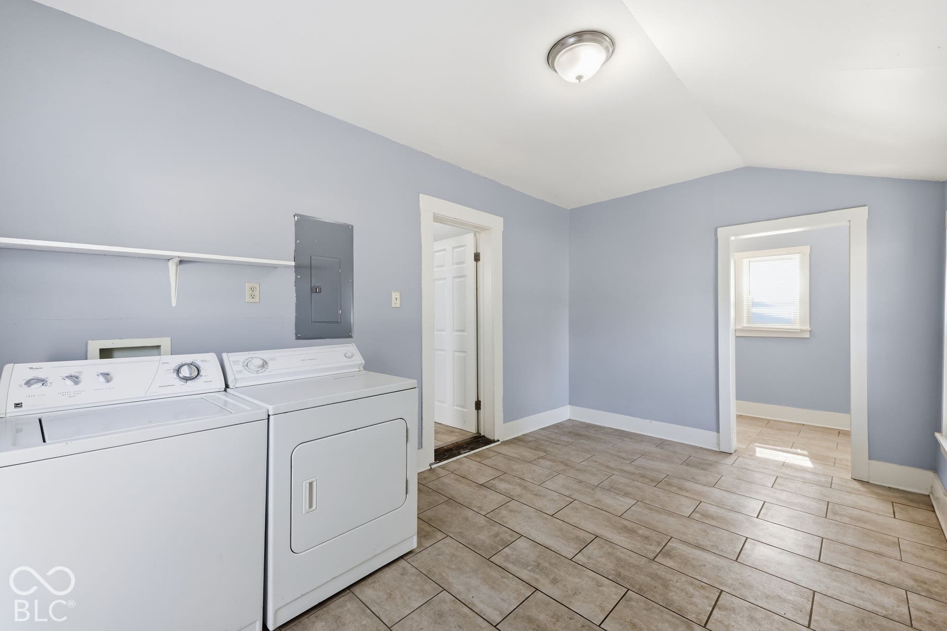 Wood-finish tile flooring, ceiling-mounted light fixture, and light-toned wall paint