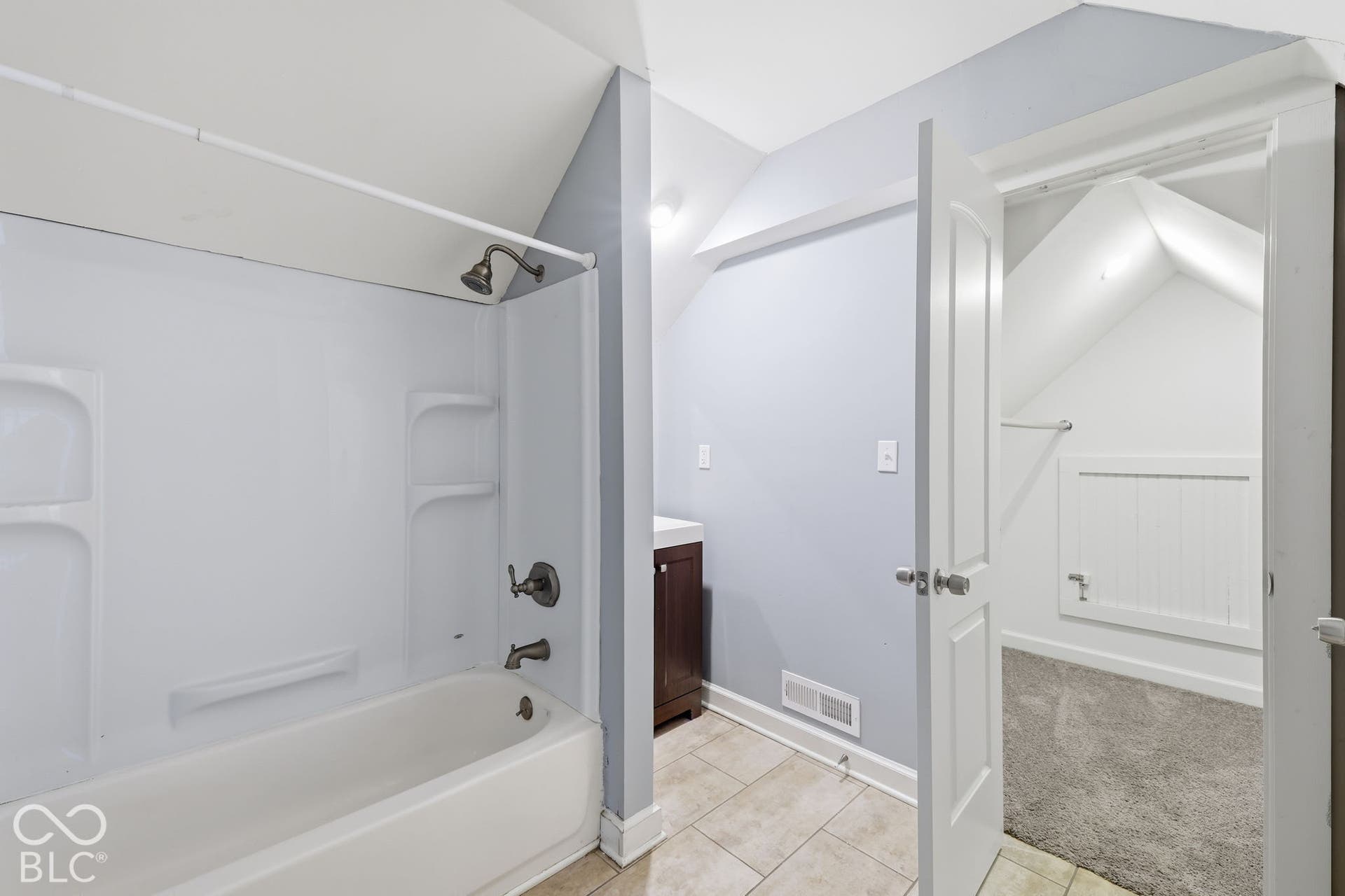 White bathtub with an integrated shower, complemented by bronze-finish fixtures