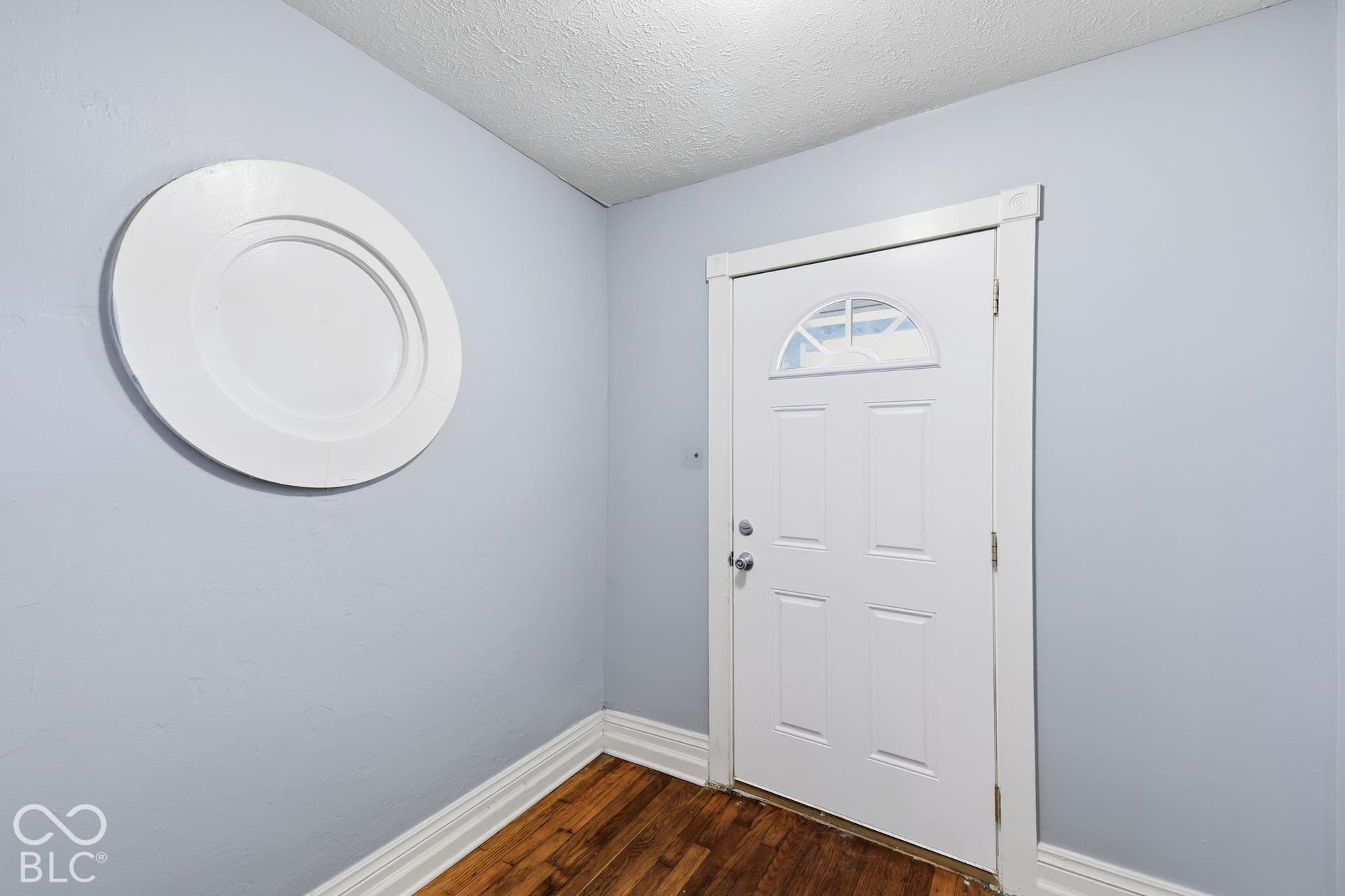 Entry door with an arched transom, paneled design, and chrome hardware