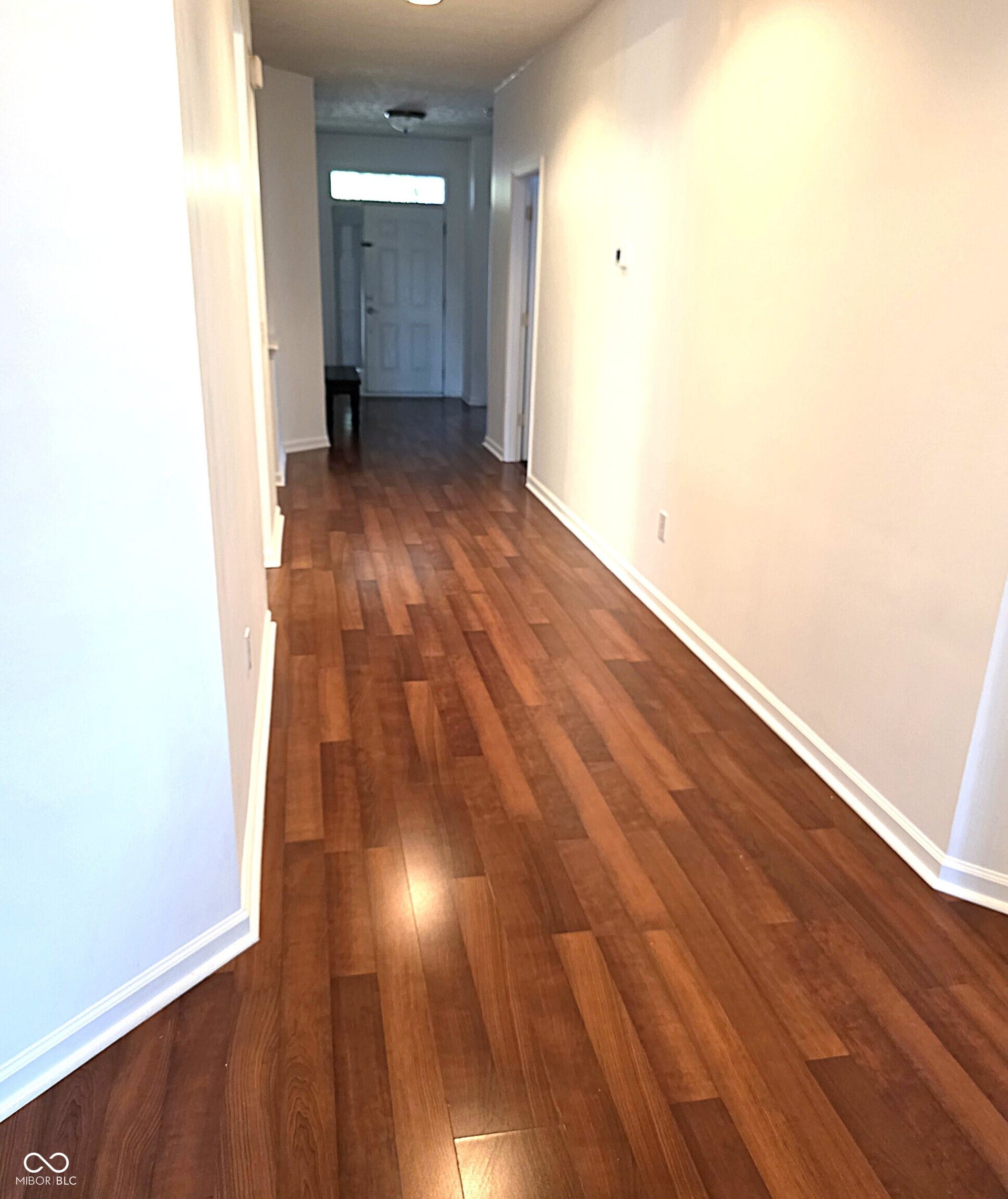 Wood-finish flooring throughout, white painted walls, and white trim