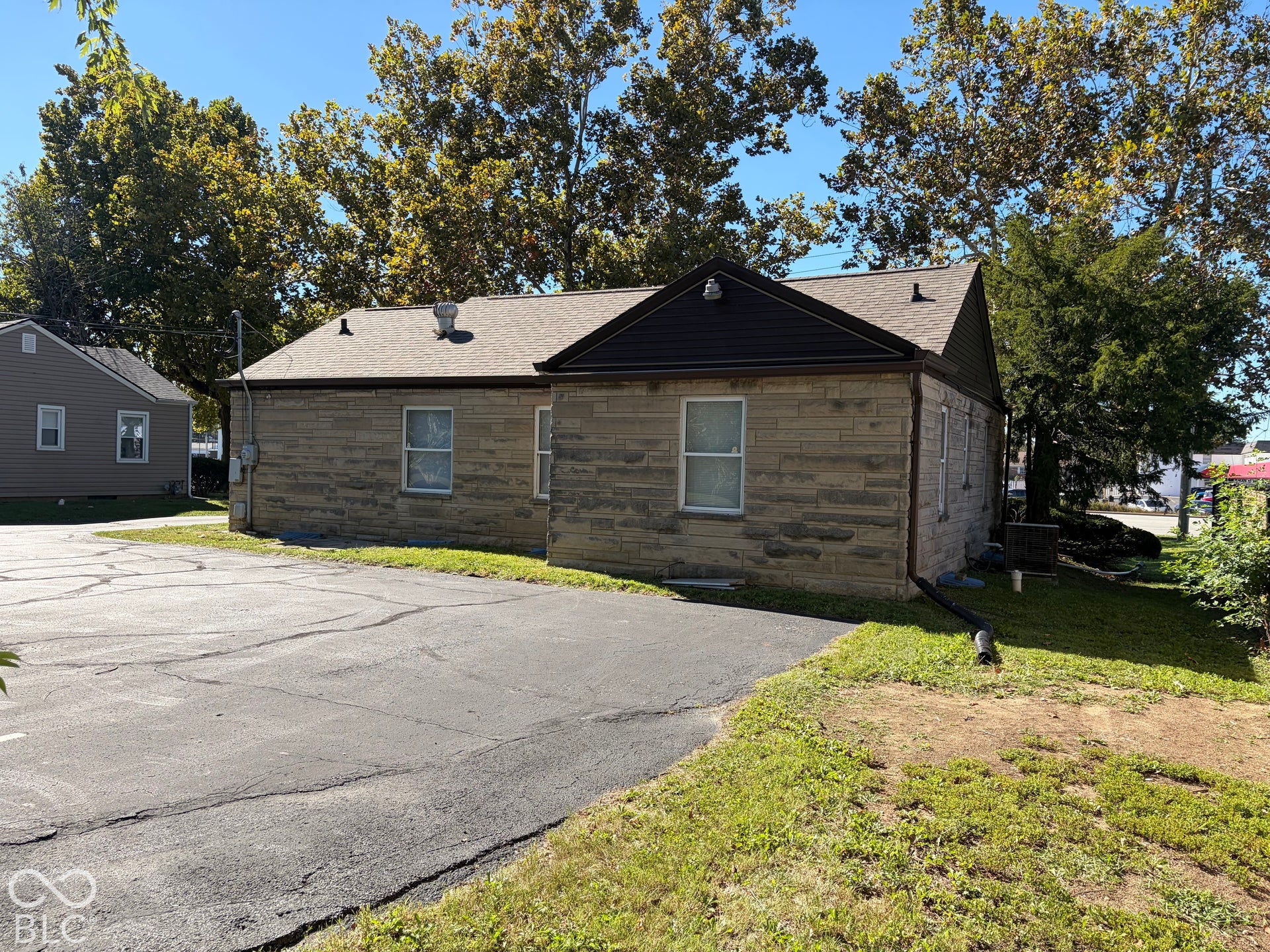 Stone exterior building with a shingle roof and multiple windows