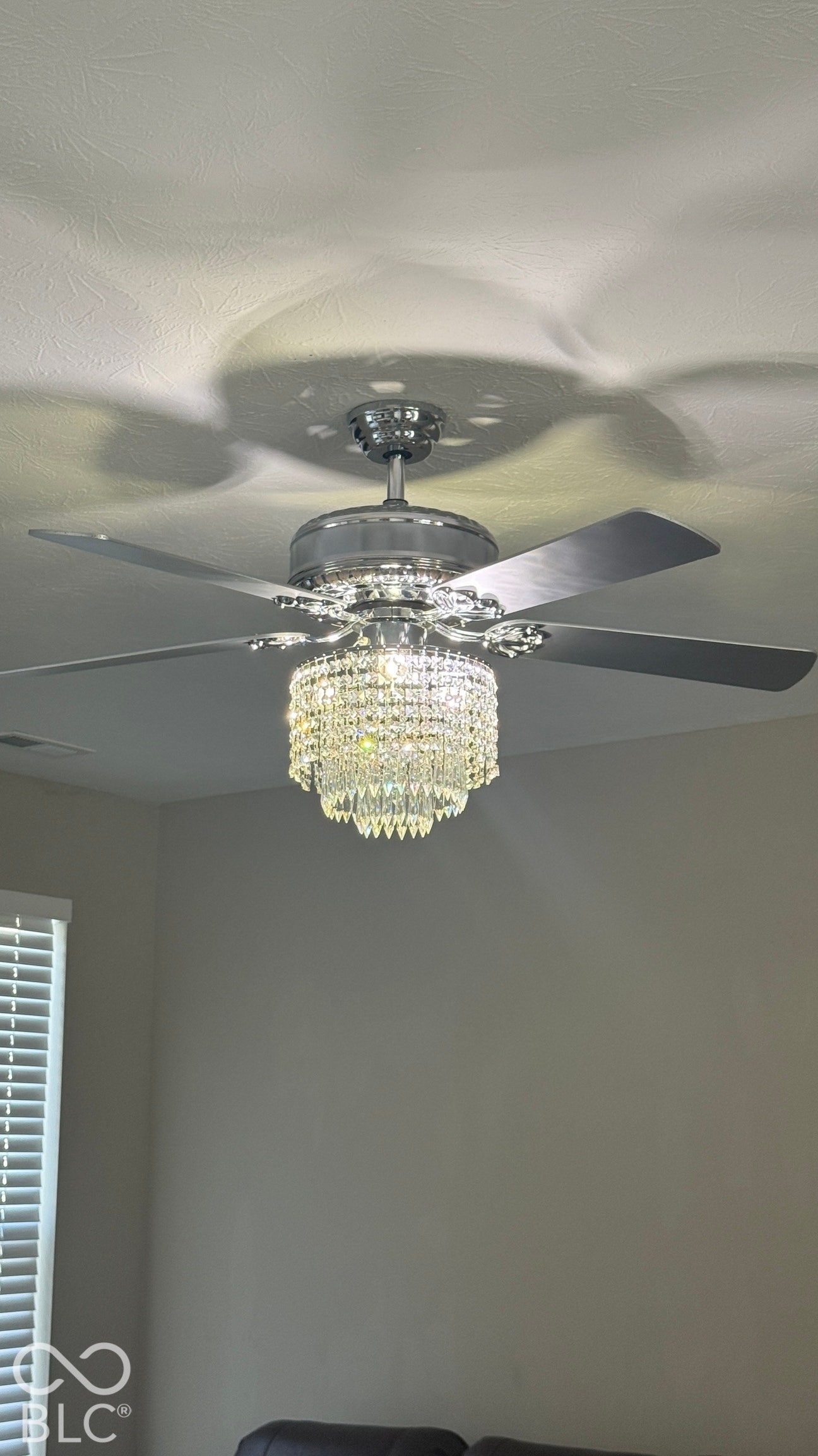 Polished chrome ceiling fan with an integrated crystal chandelier light fixture