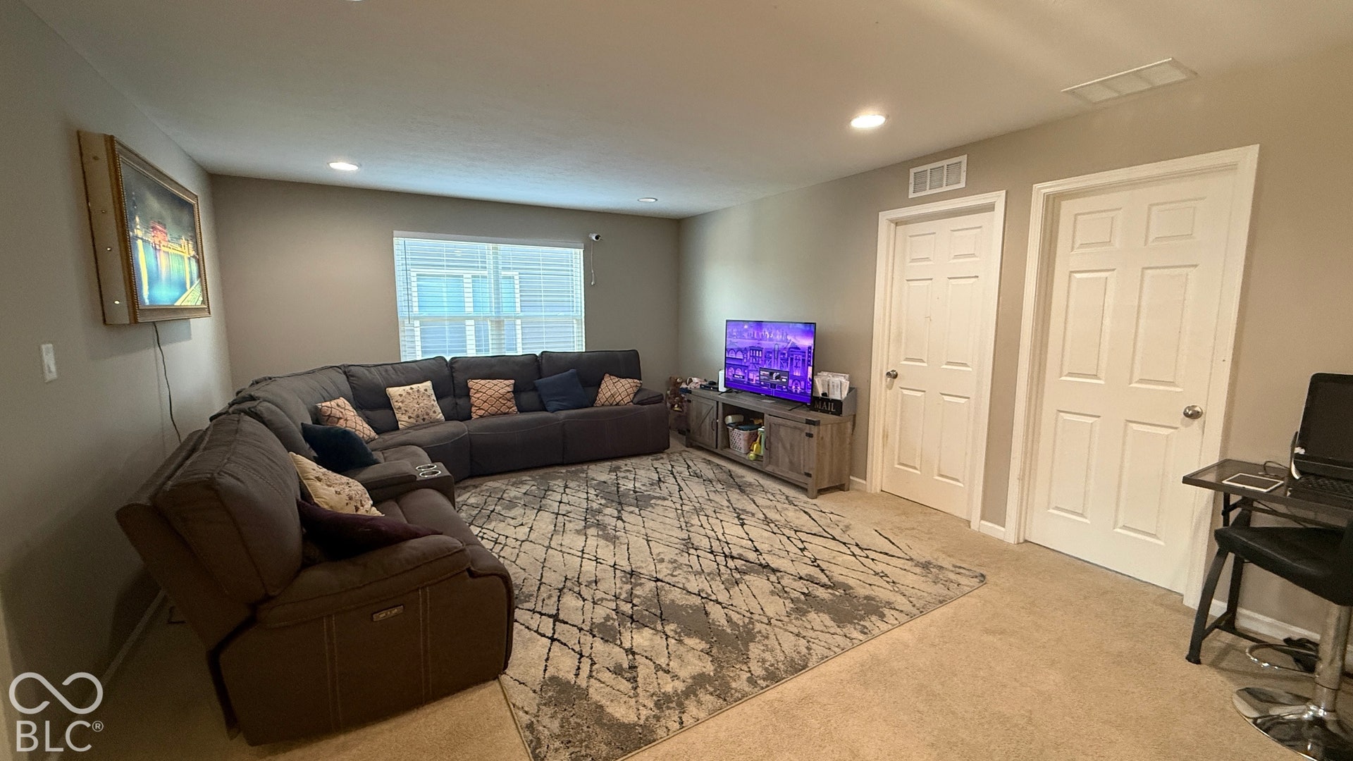 Recessed lighting illuminates the room with neutral-toned walls