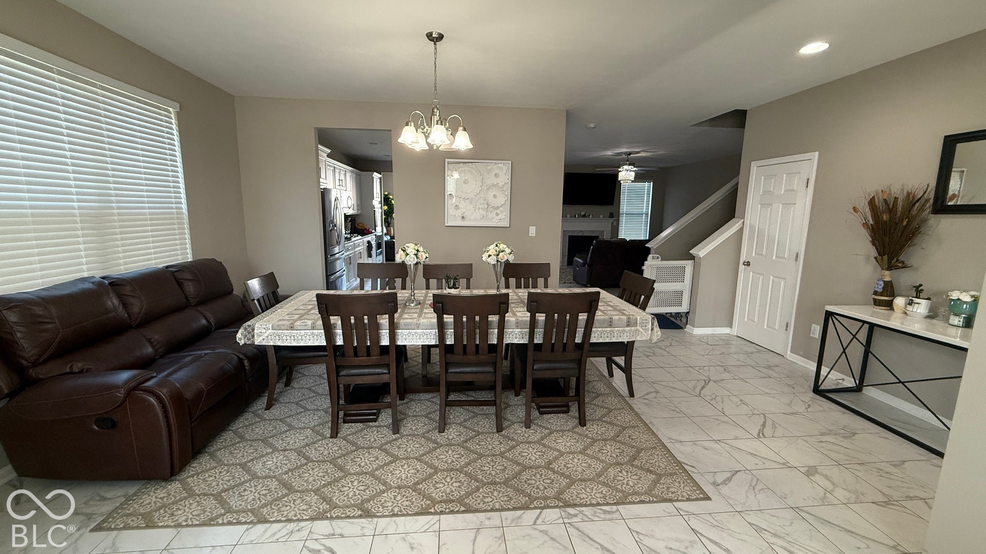 Expansive tile flooring, chandelier lighting, and a window with blinds