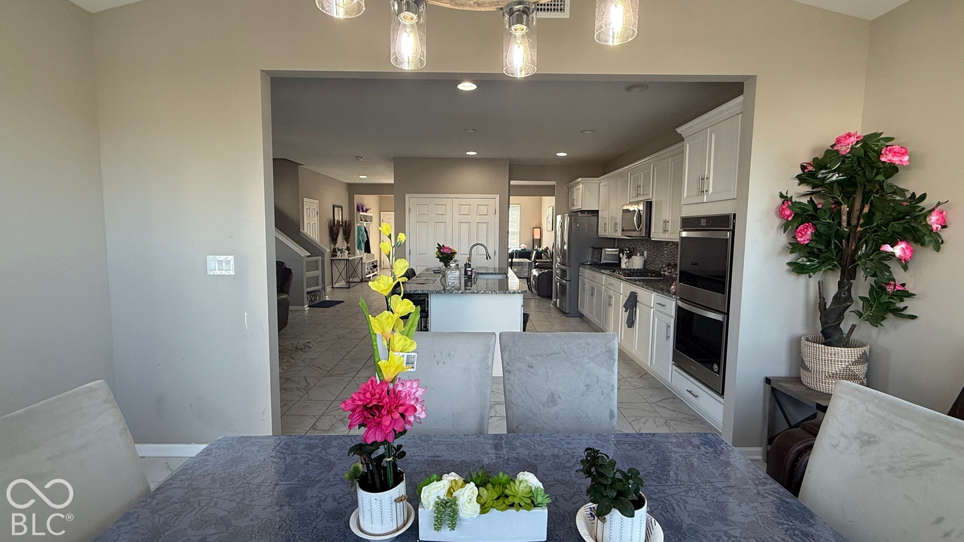 Kitchen featuring white cabinetry, stainless steel appliances, recessed lighting, and a kitchen island with a sink