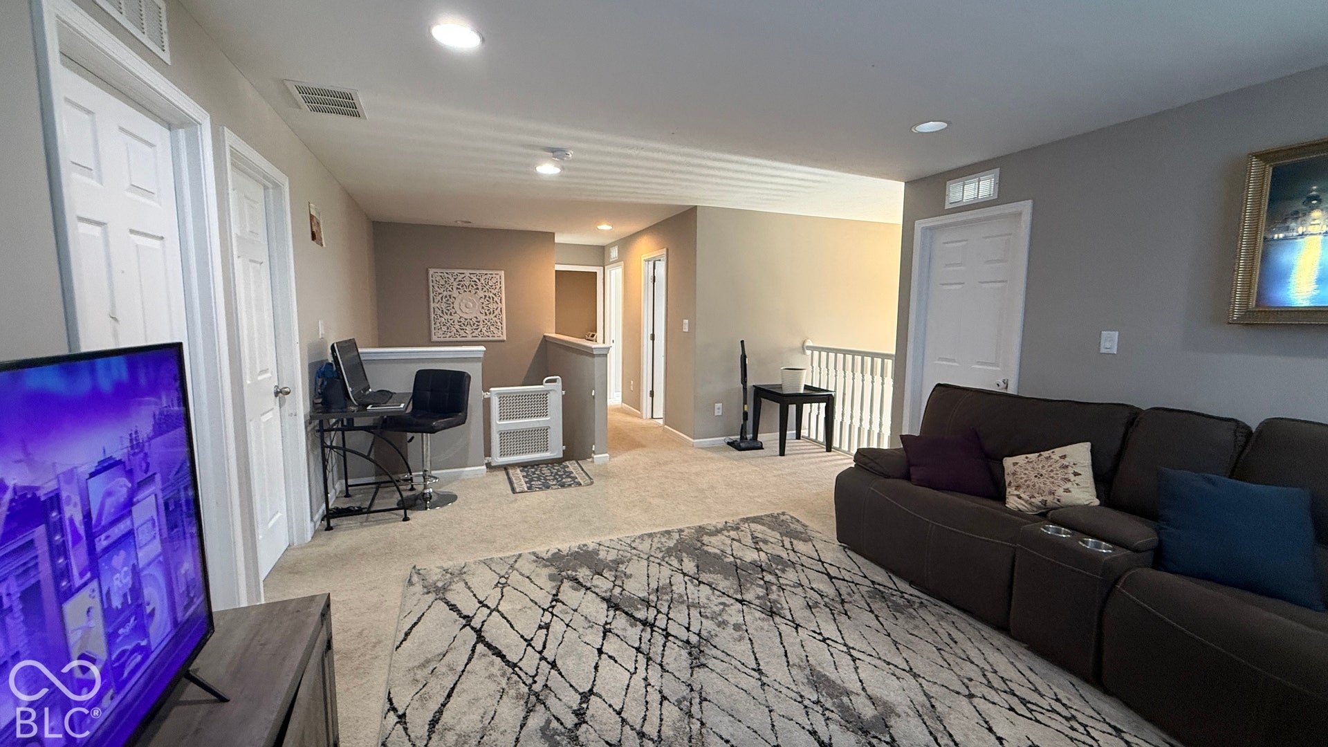 Carpeted loft area featuring recessed lighting, white interior doors, and a white banister