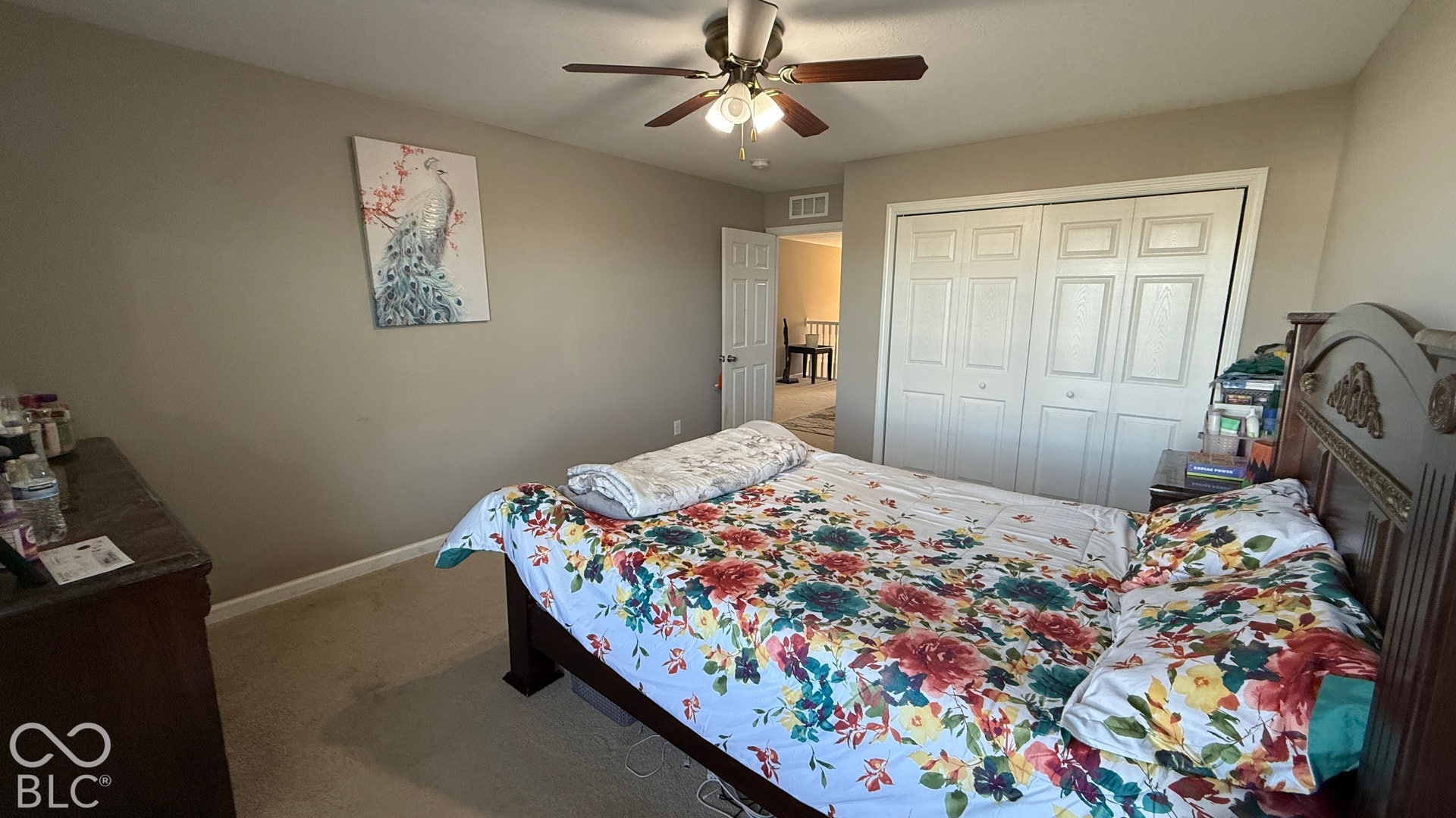 Neutral wall paint, ceiling fan with integrated lighting, and carpeted flooring