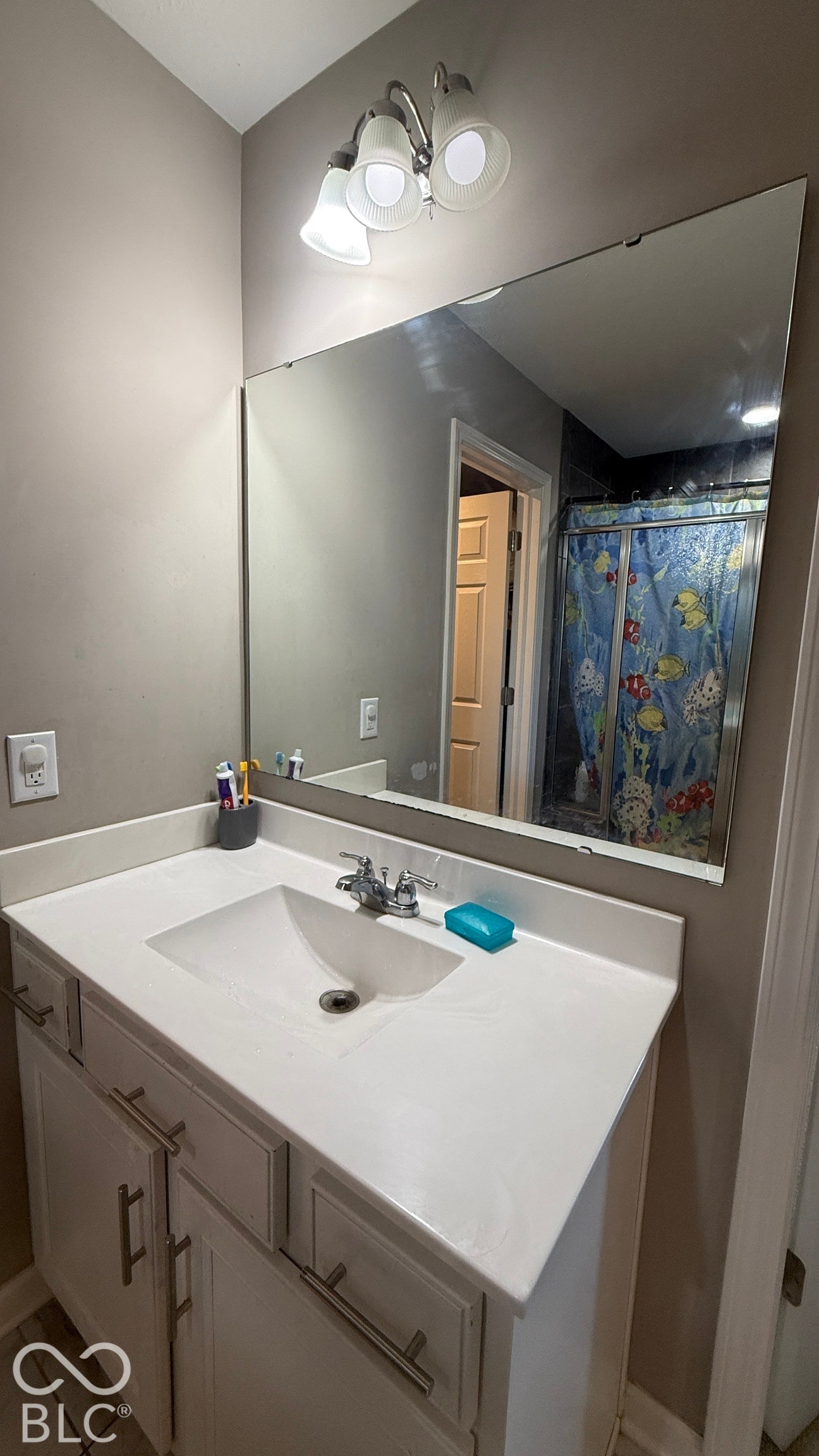Vanity with integrated sink, chrome faucet, and white cabinetry