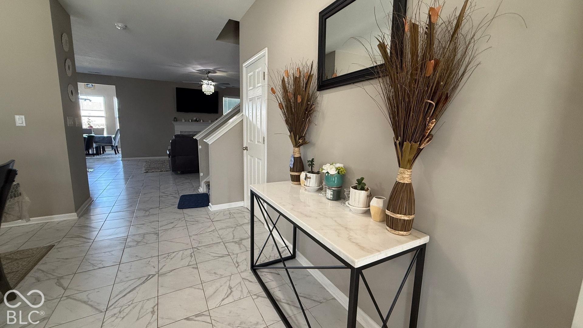 Entryway featuring tile flooring, painted walls, and a staircase with white risers and handrail