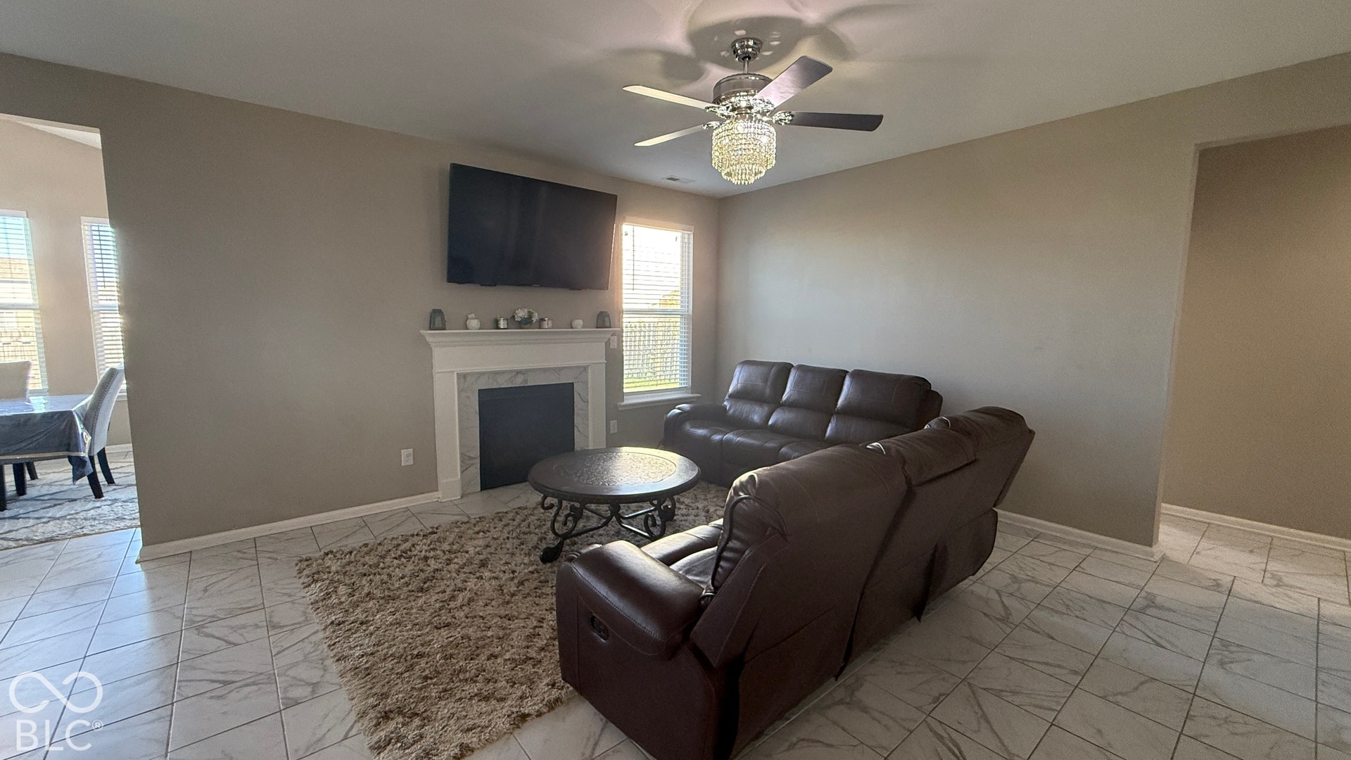Recessed lighting, ceiling fan with chandelier light fixture, white tile flooring, white fireplace mantel, and built-in fireplace