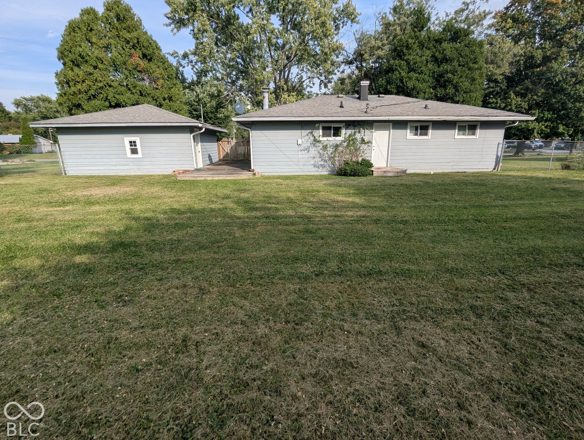 364 Robbins Drive, Greenwood, IN 46142 Expansive backyard featuring a sprawling lawn, mature trees, a detached garage, and perimeter chain-link fencing