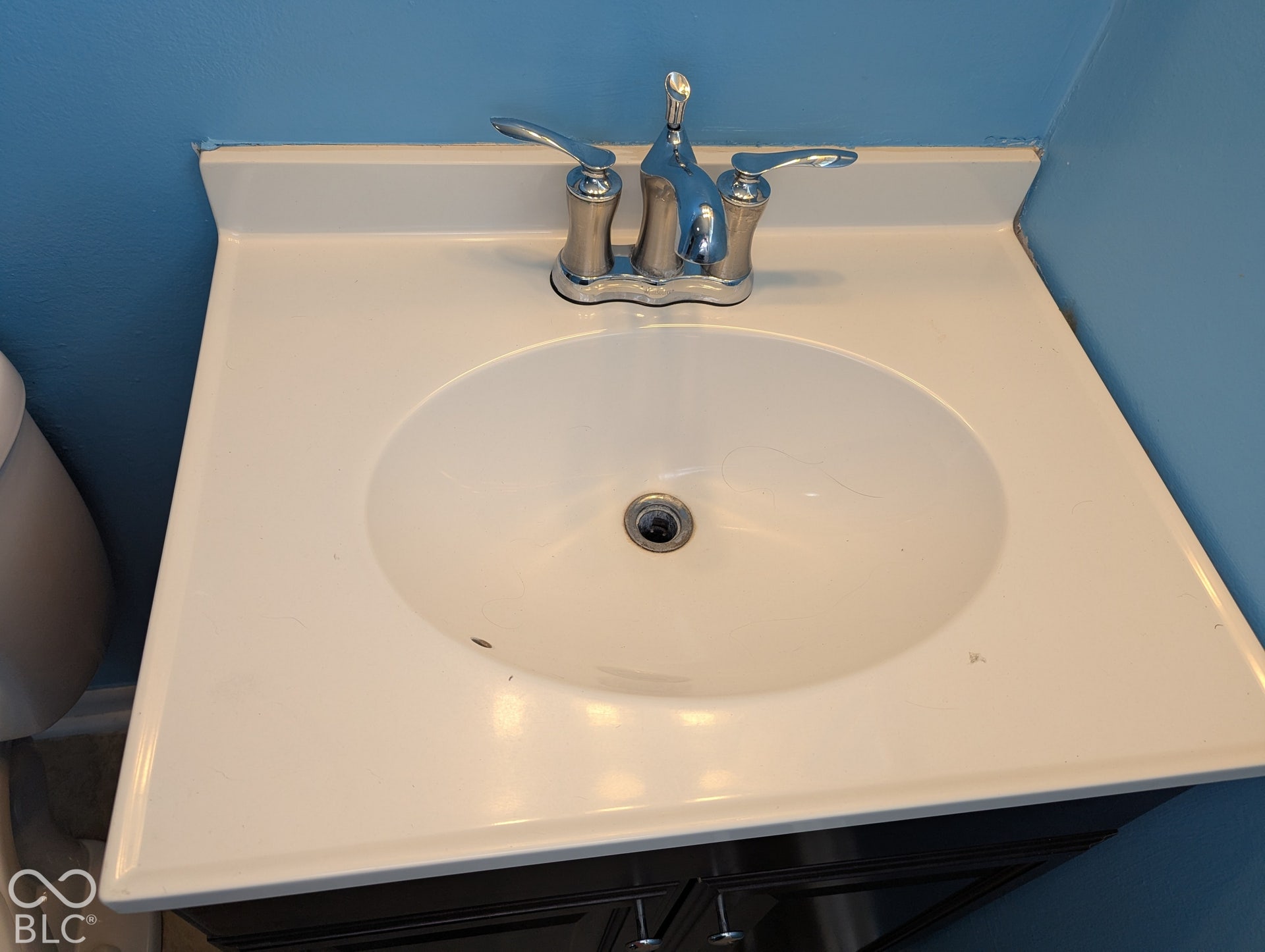 364 Robbins Drive, Greenwood, IN 46142 Integrated white vanity sink with a chrome two-handle faucet and dark wood-finish cabinetry