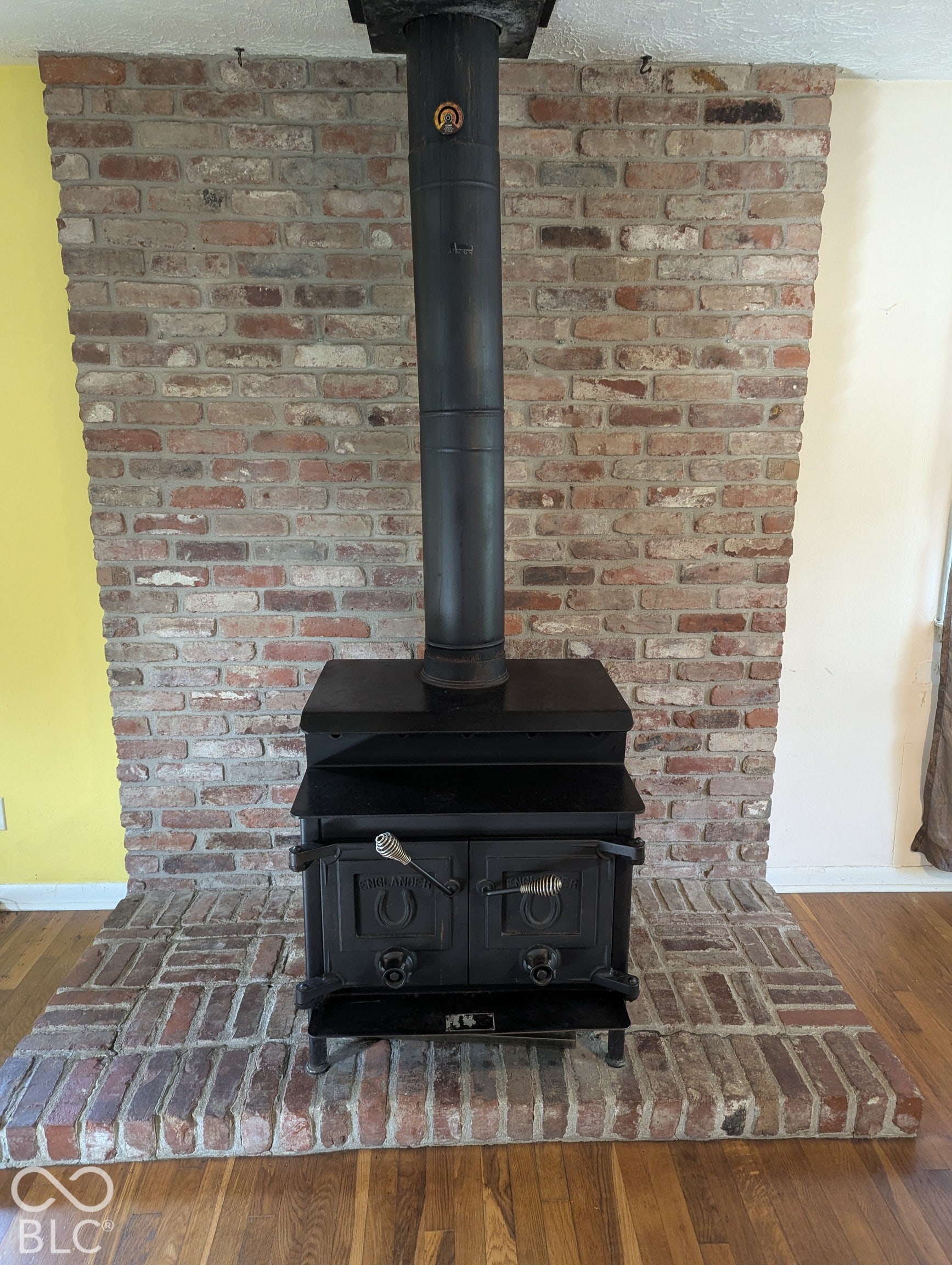 364 Robbins Drive, Greenwood, IN 46142 Cast iron wood-burning stove with a brick-clad chimney and brick hearth