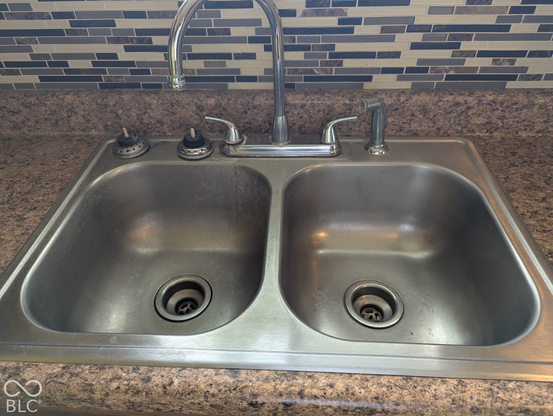 364 Robbins Drive, Greenwood, IN 46142 Double-basin stainless steel sink with a high-arc faucet, separate spray nozzle, and mosaic tile backsplash