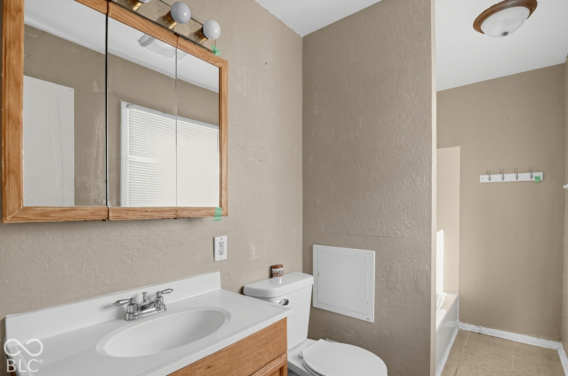 3733 Ireland Drive, Indianapolis, IN 46235 Vanity with integrated sink, chrome faucet, and wood-framed mirrored medicine cabinet