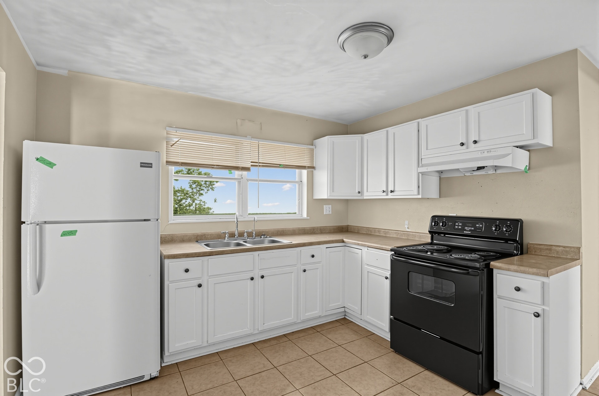 3733 Ireland Drive, Indianapolis, IN 46235 White cabinetry with black hardware, double basin sink, neutral countertops, and tile flooring