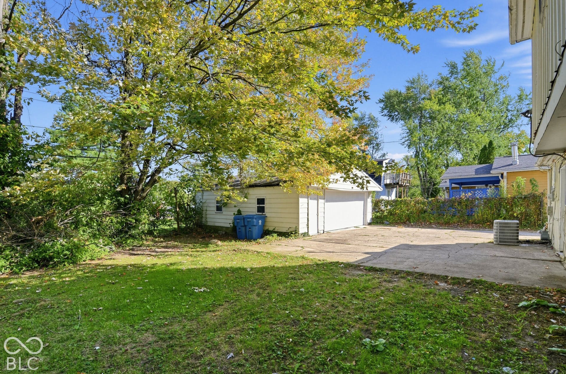 3733 Ireland Drive, Indianapolis, IN 46235 Grassed yard area with mature trees, concrete patio, and detached garage