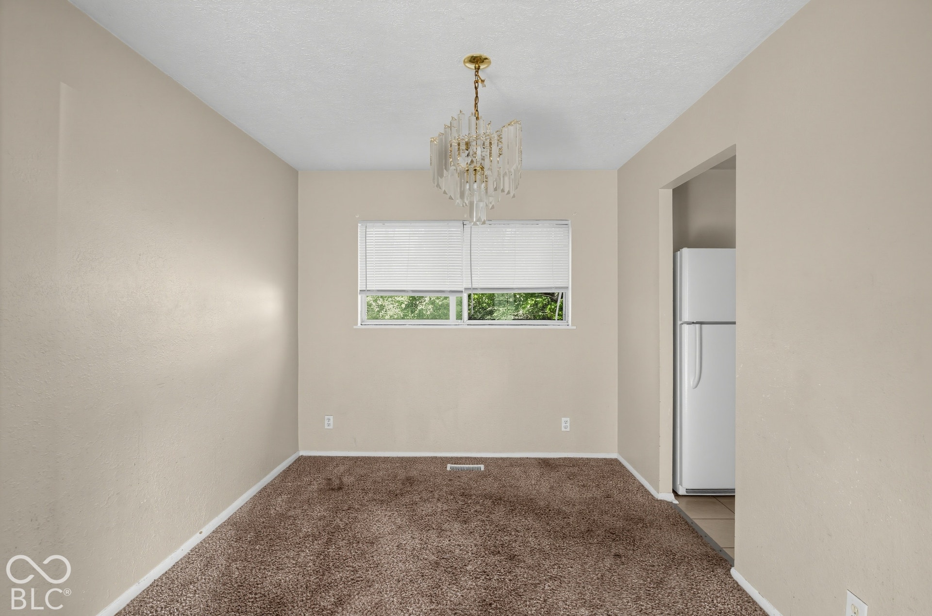 3733 Ireland Drive, Indianapolis, IN 46235 Central window with white blinds, gold-toned chandelier, and light-toned wall paint