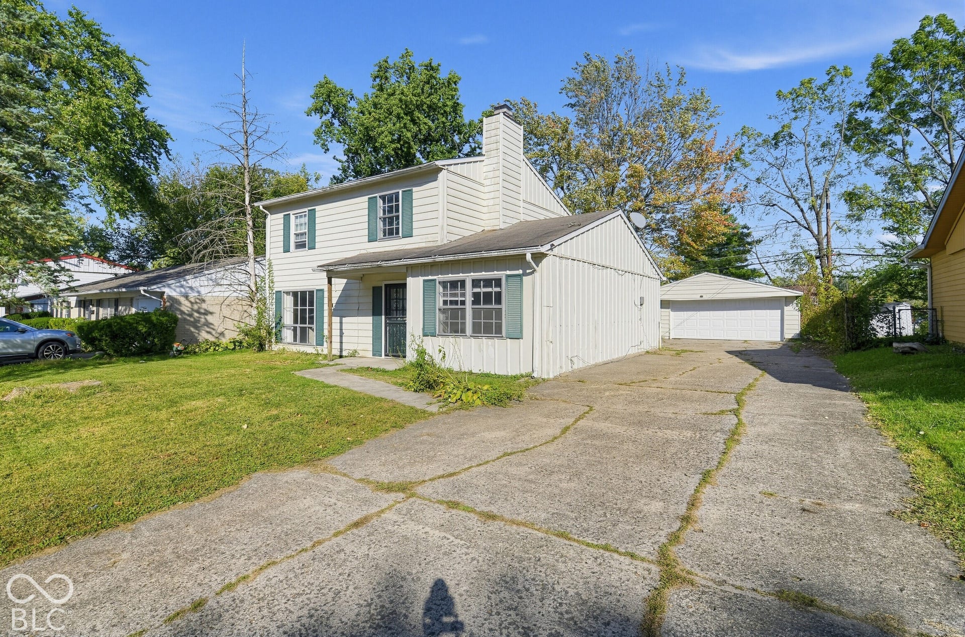 3733 Ireland Drive, Indianapolis, IN 46235 Two-story exterior with light-colored siding, green window shutters, and a prominent chimney