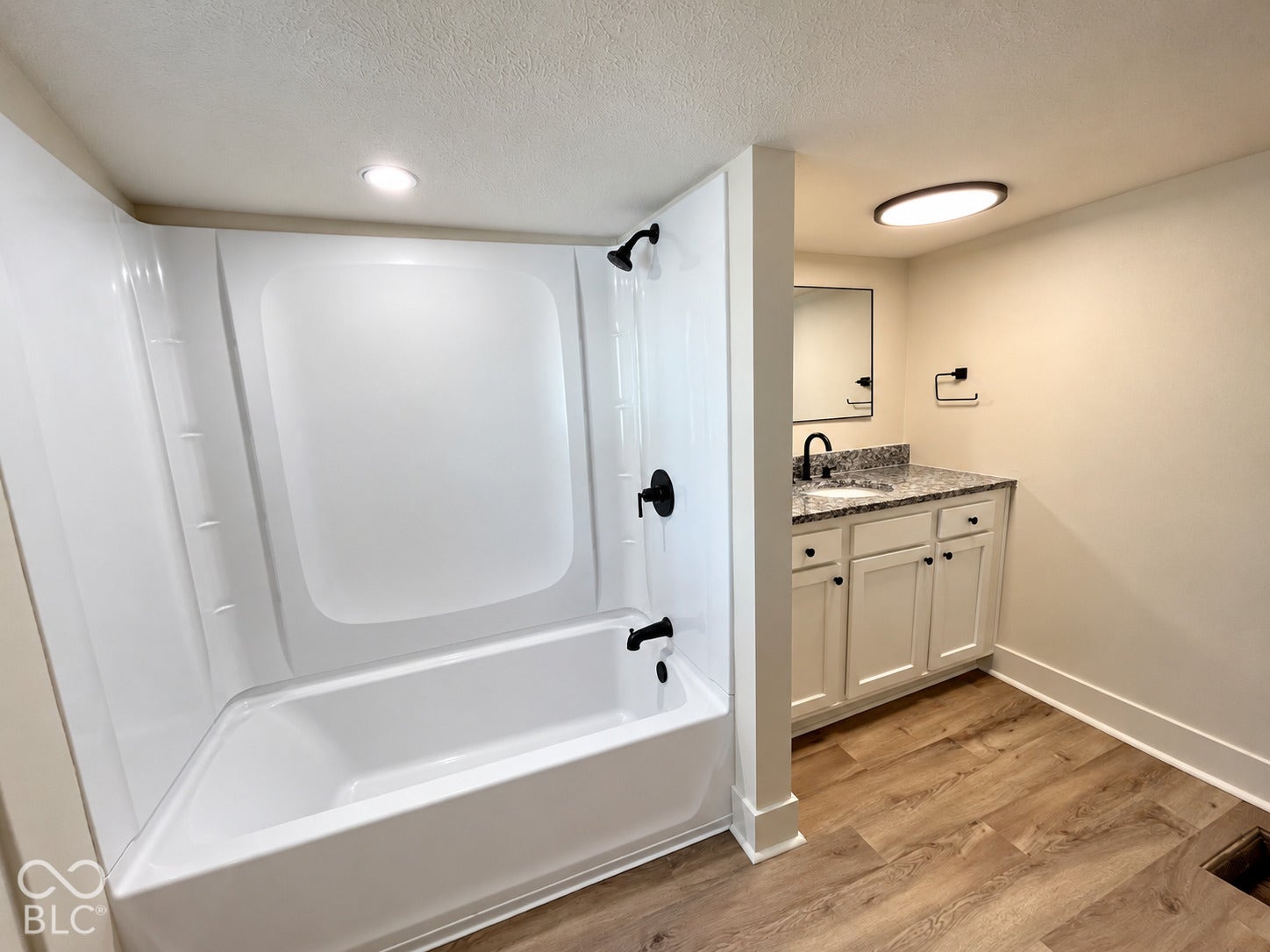 White bathtub and shower combination with matte black fixtures