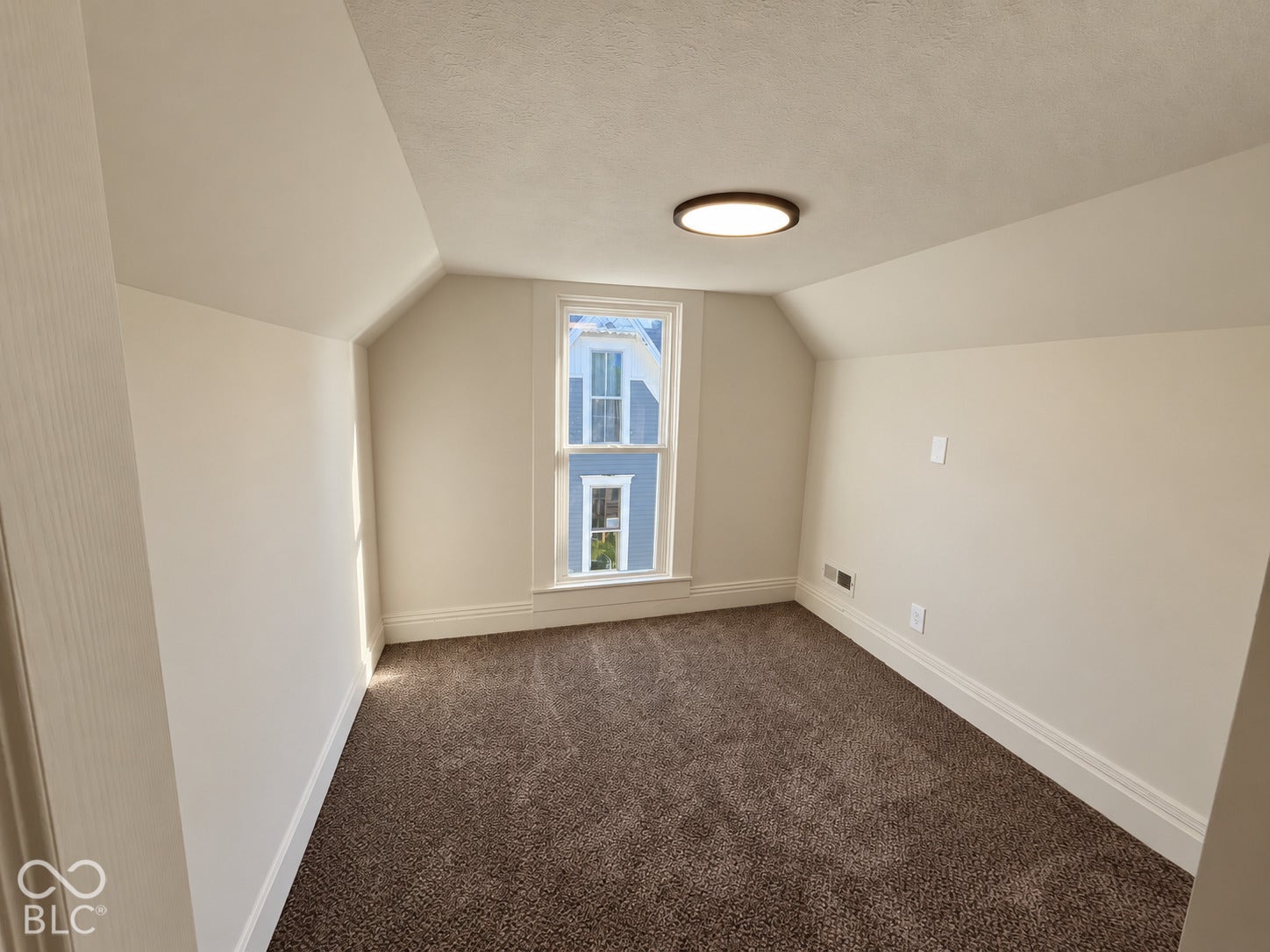 Room featuring a single window, sloped ceilings, textured ceiling finish, recessed lighting fixture, and brown carpet flooring
