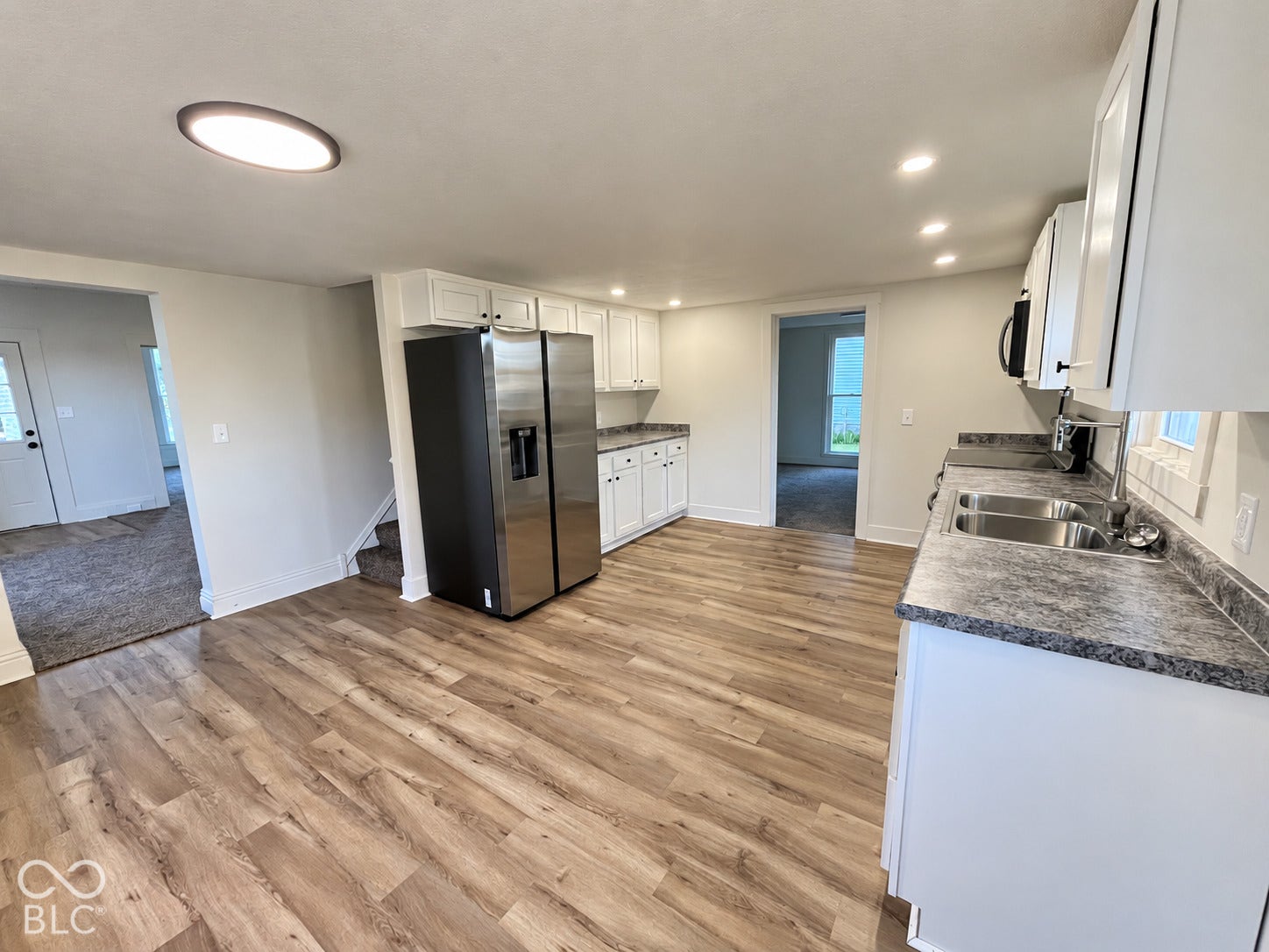 Kitchen featuring wood-finish flooring, white cabinetry, stainless steel appliances, and recessed lighting