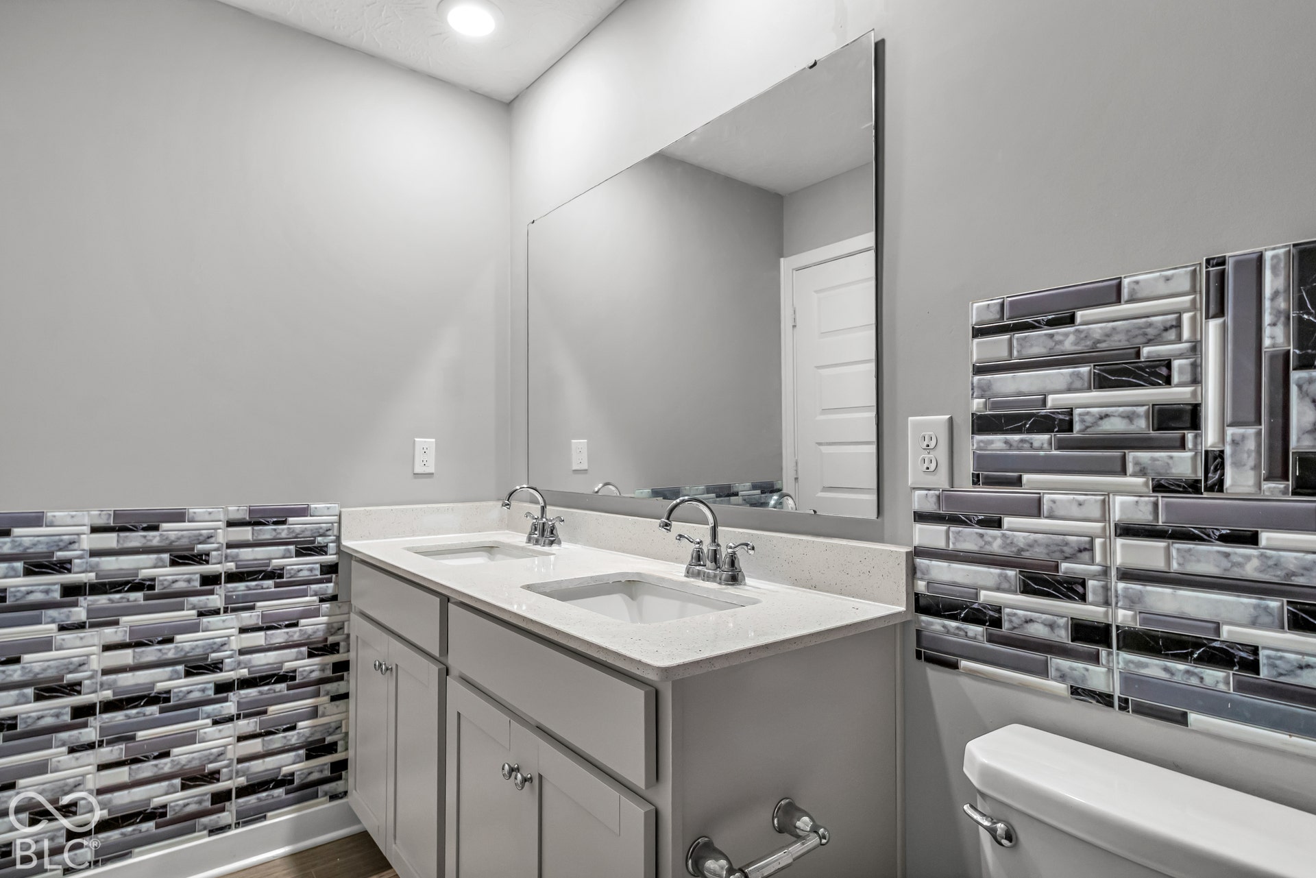 Double vanity with integrated sinks, polished chrome fixtures, and light-toned countertops
