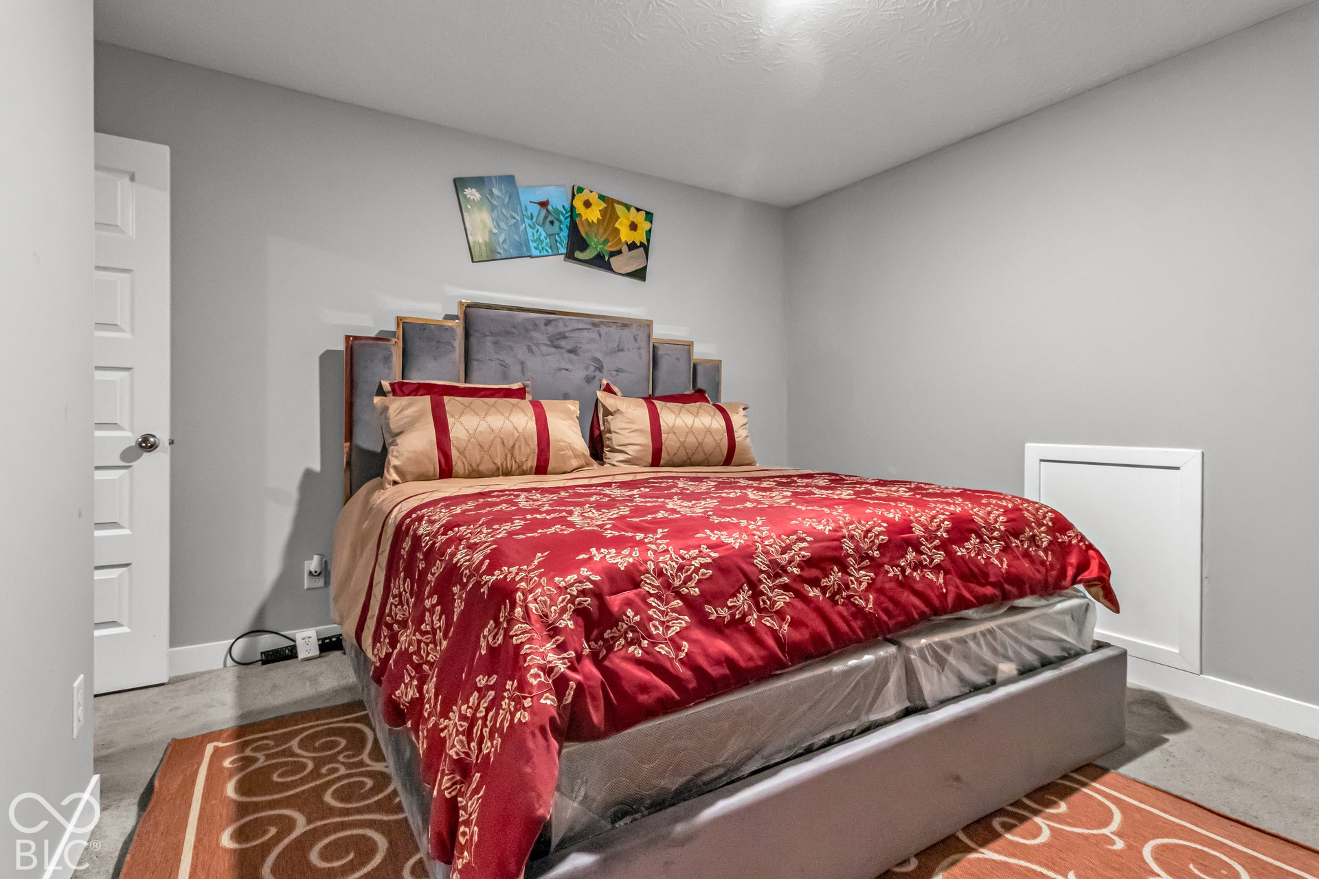 Painted gray walls, white ceiling, white paneled door, gray carpeting, and a white wall access panel
