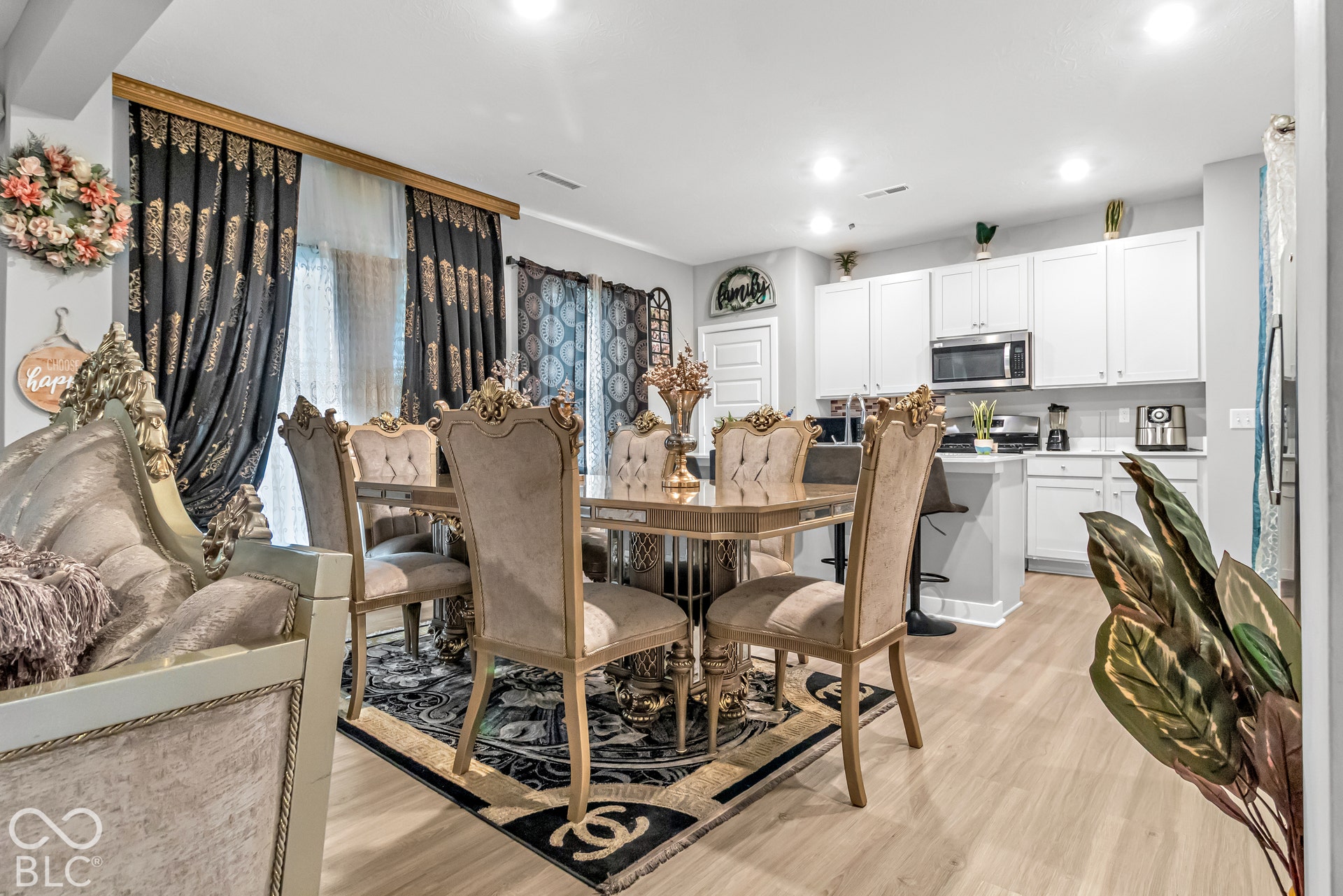 Open-concept living space with wood-finish flooring, recessed lighting, and white cabinetry