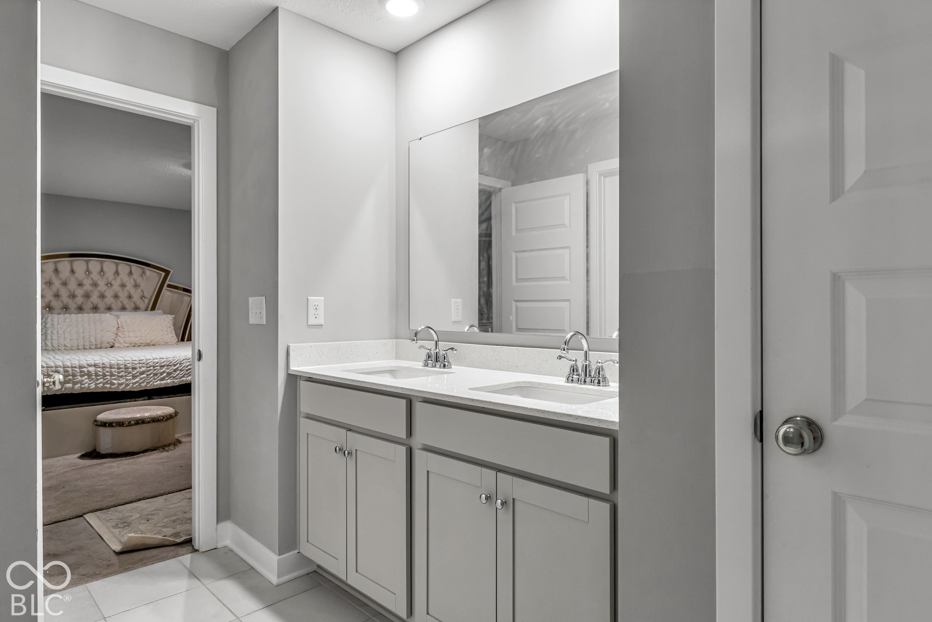 Dual vanity with undermount sinks, chrome fixtures, and a large wall-mounted mirror