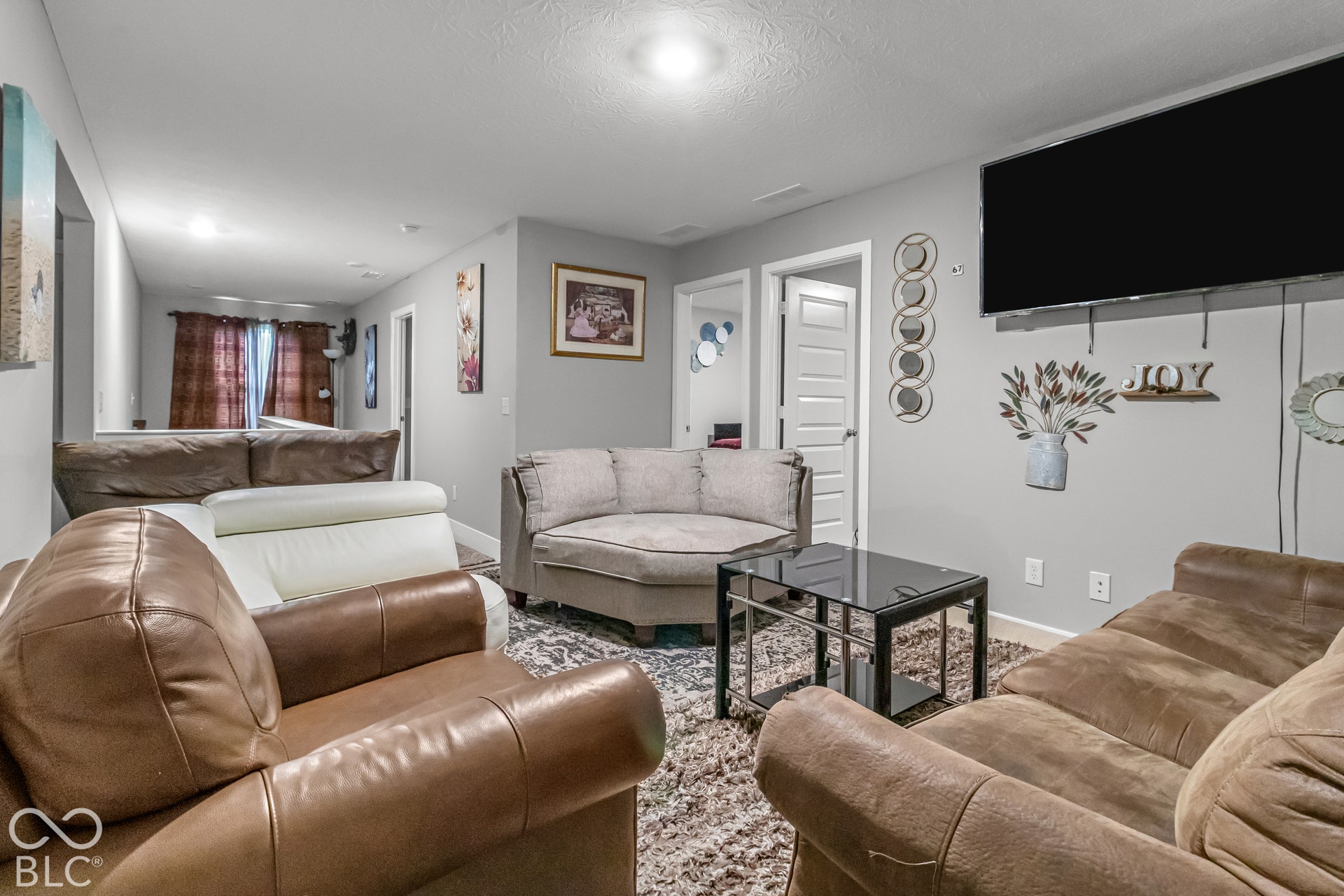 Recessed lighting illuminates the neutral wall tones and textured ceiling
