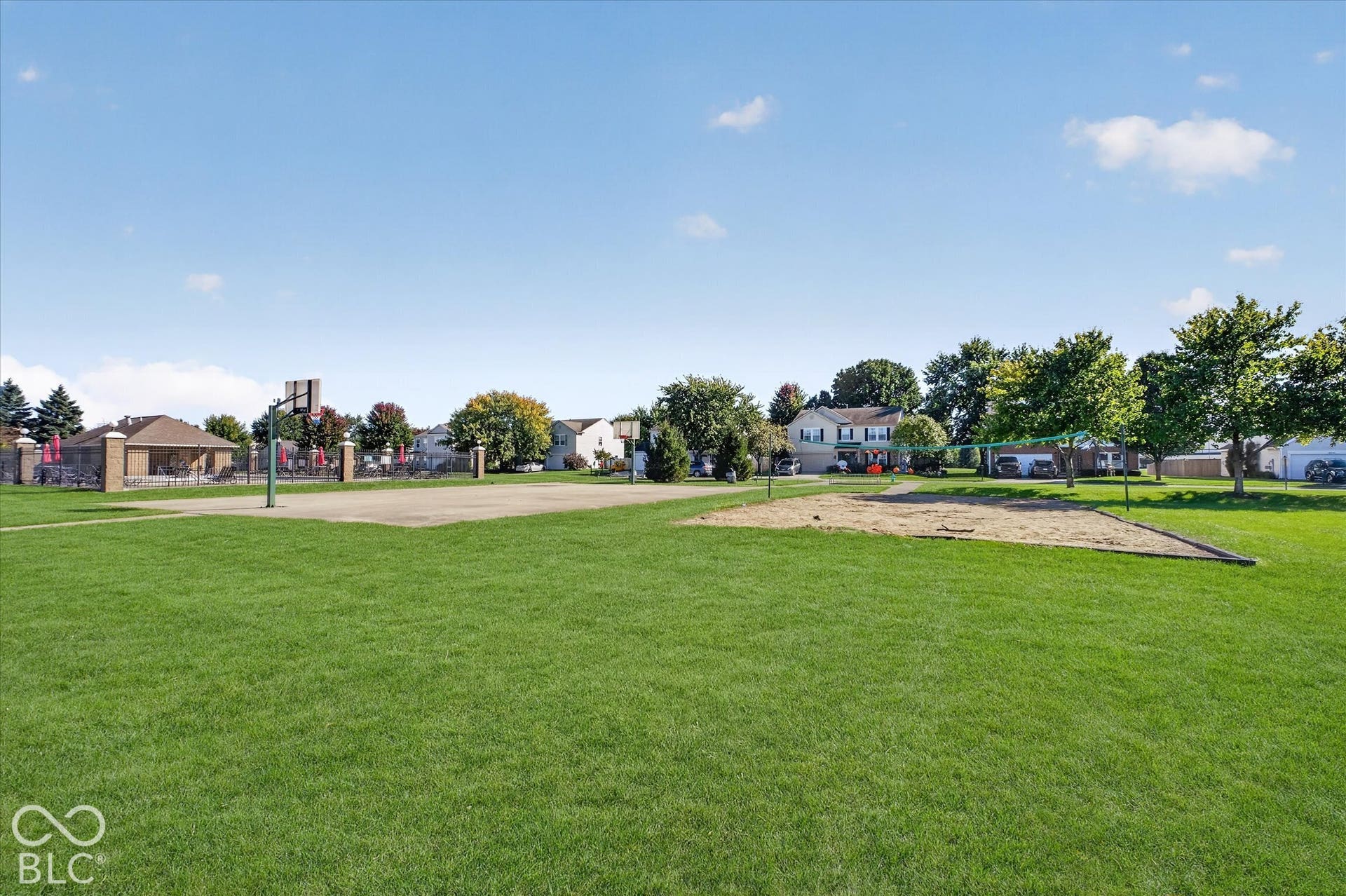 12980 Coyote Run, Fishers, IN 46038 Expansive green space with a basketball court, sand play area, and perimeter fencing