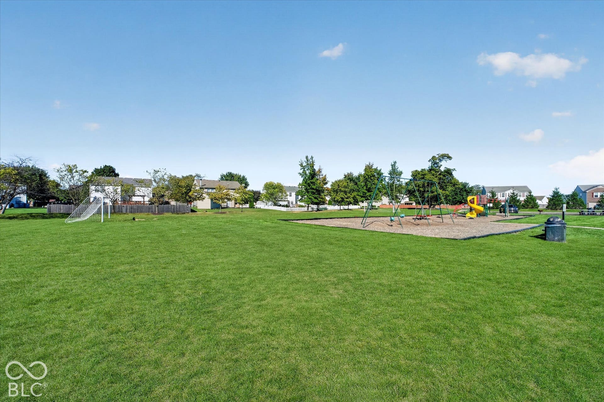 12980 Coyote Run, Fishers, IN 46038 Expansive green space featuring a playground with slides and swings, a soccer goal, and mature trees