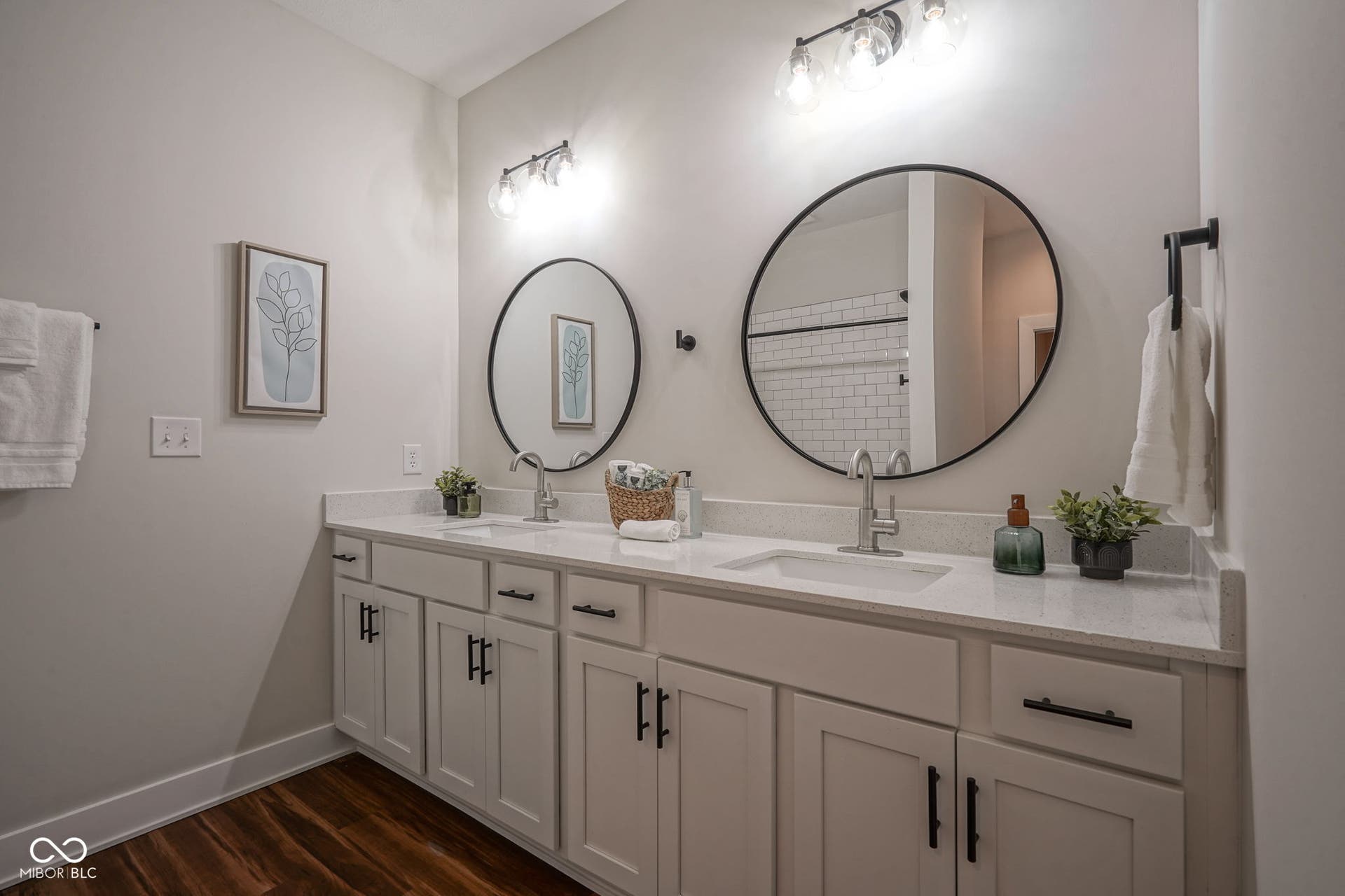 bathroom with double vanity and dark wood-style floors