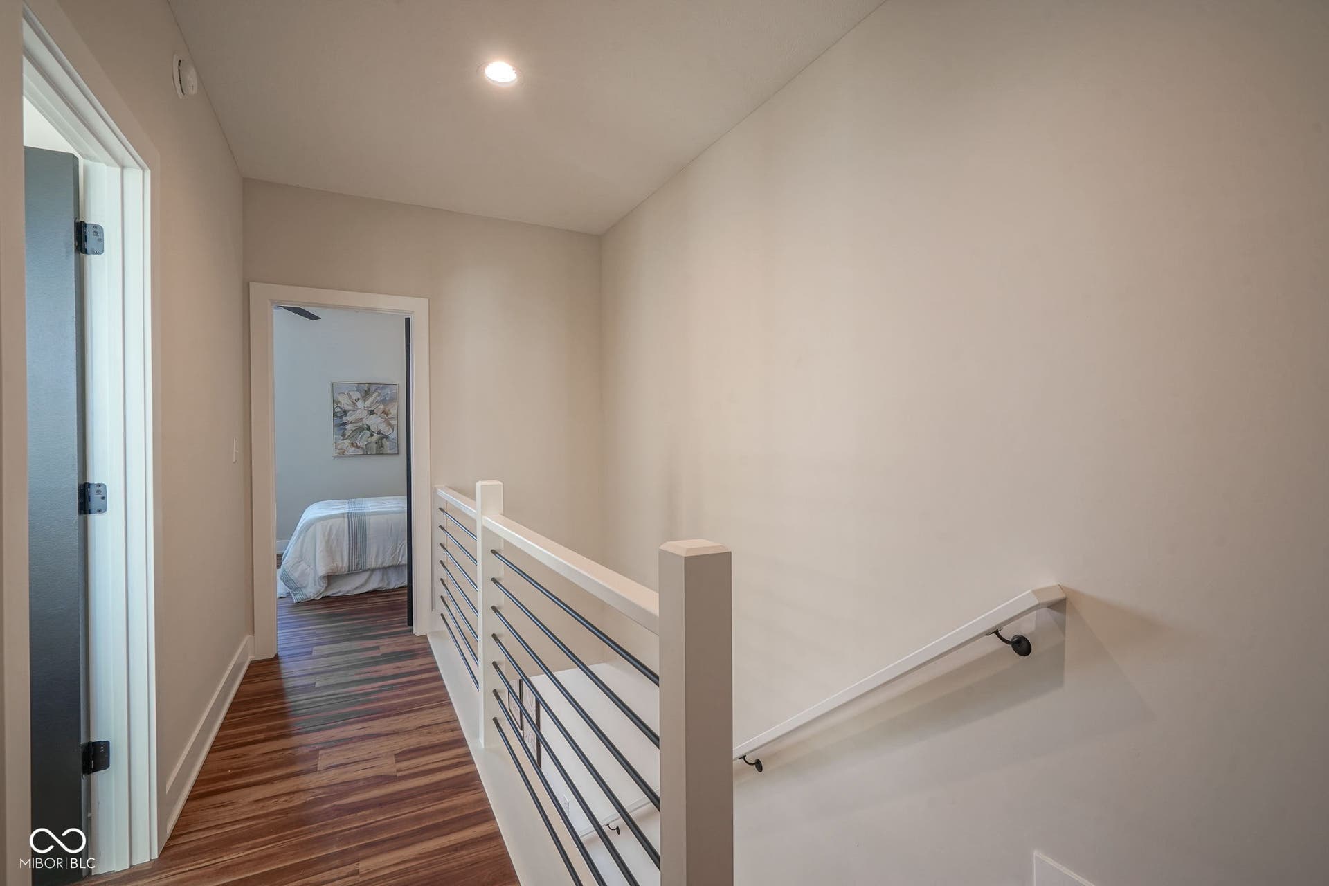 hall with an upstairs landing, dark wood-type flooring, and recessed lighting