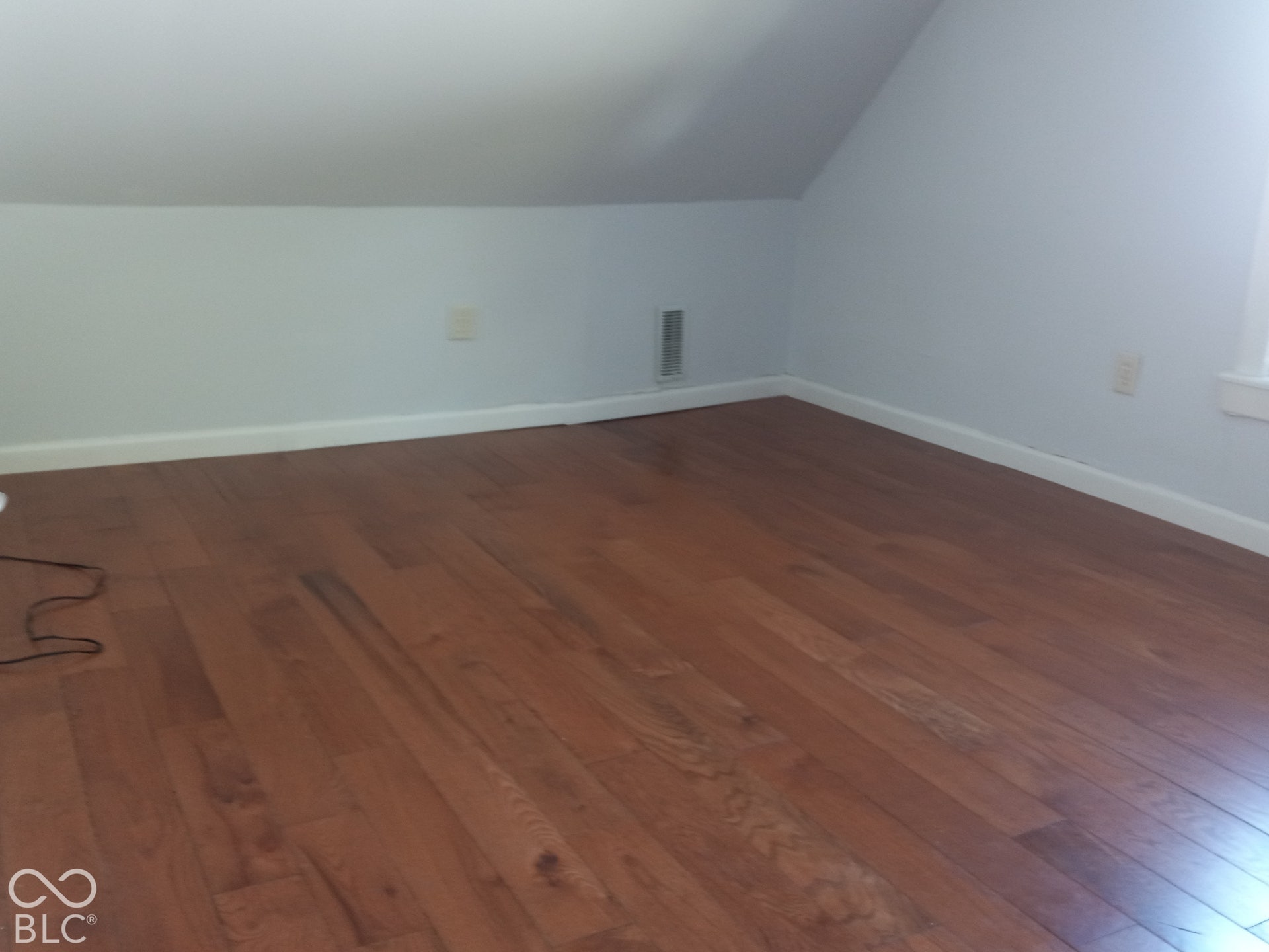 Wood-finish flooring with white baseboards and light-colored walls