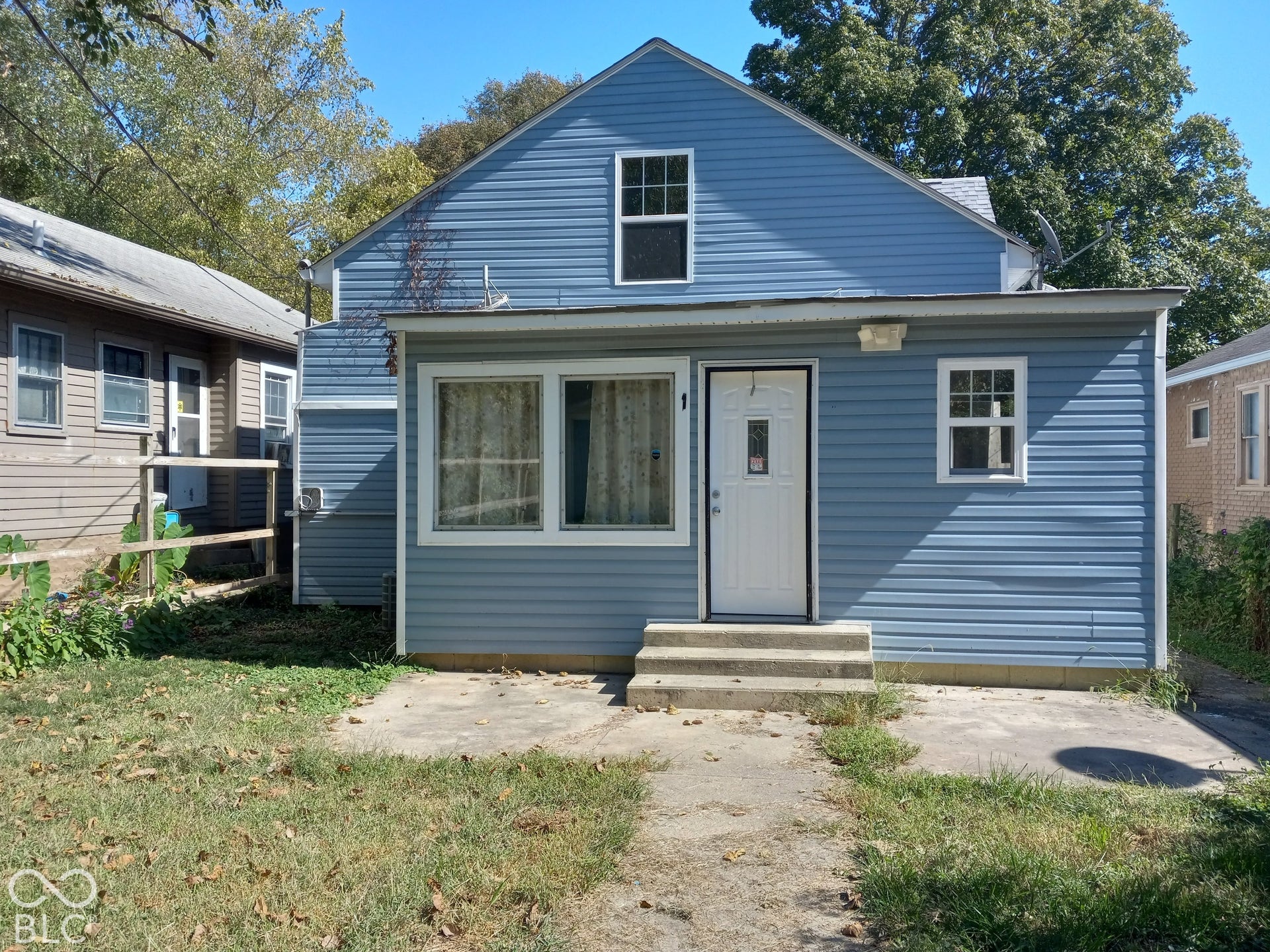 Light blue siding exterior with a white entry door and two front windows