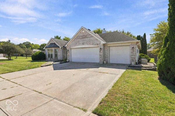 Light-colored brick exterior with gabled roof lines and a two-car garage