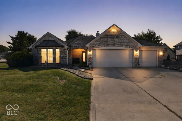 Stone veneer exterior with a concrete driveway, two-car garage, and an additional single-car garage