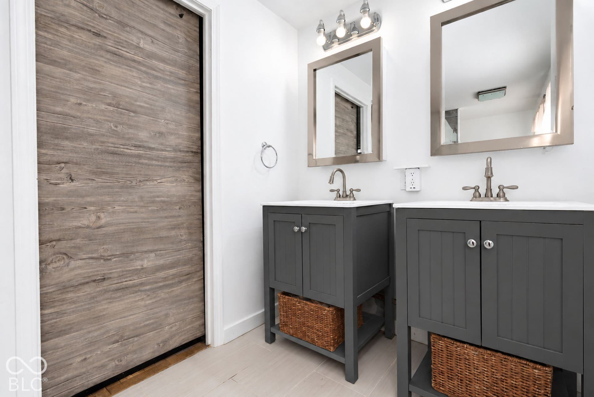 Dual vanity with integrated sinks, brushed nickel fixtures, contemporary wall-mounted mirrors, and sleek gray cabinetry