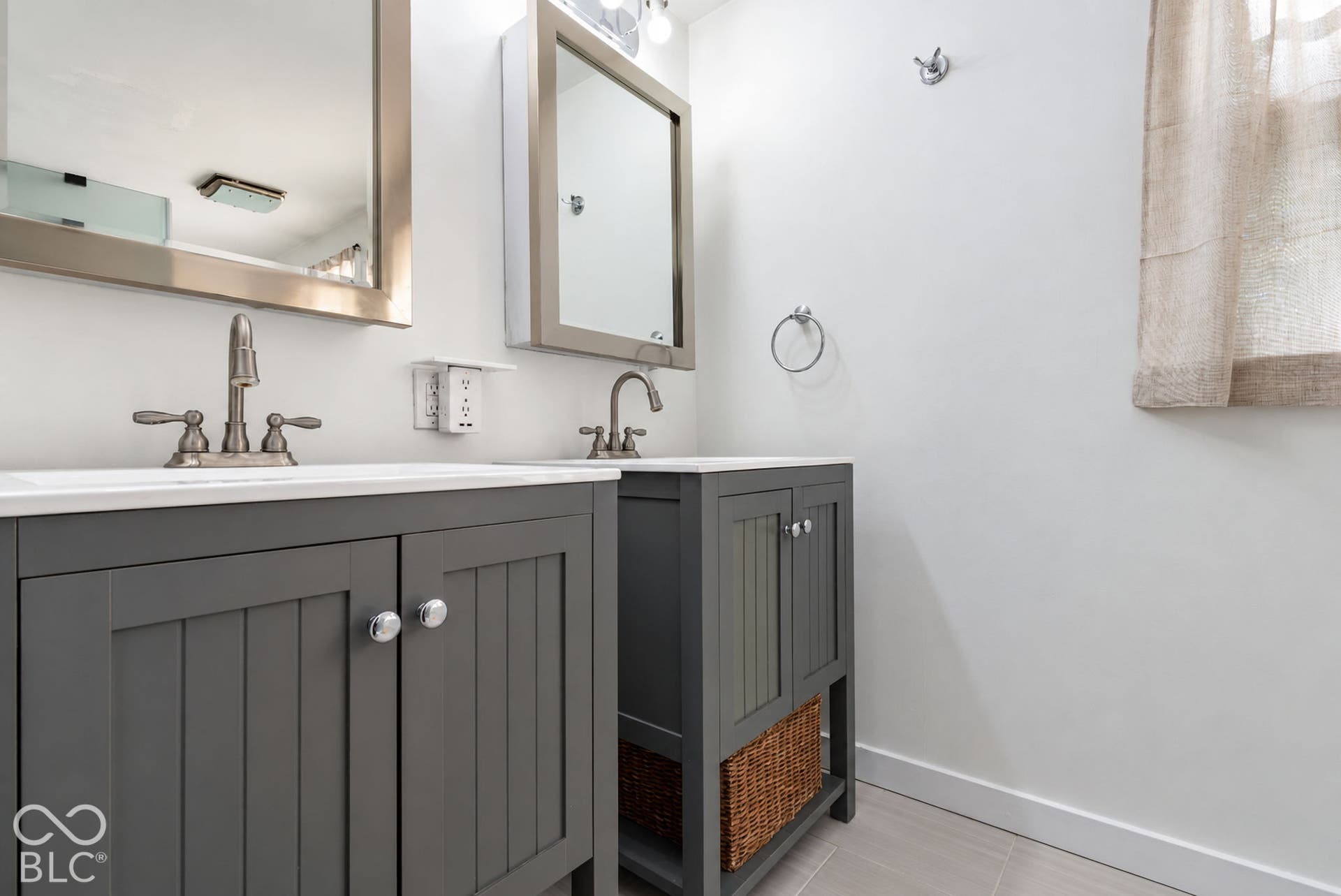 Dual vanities with white countertops, gray wood-finish cabinetry, and brushed nickel fixtures