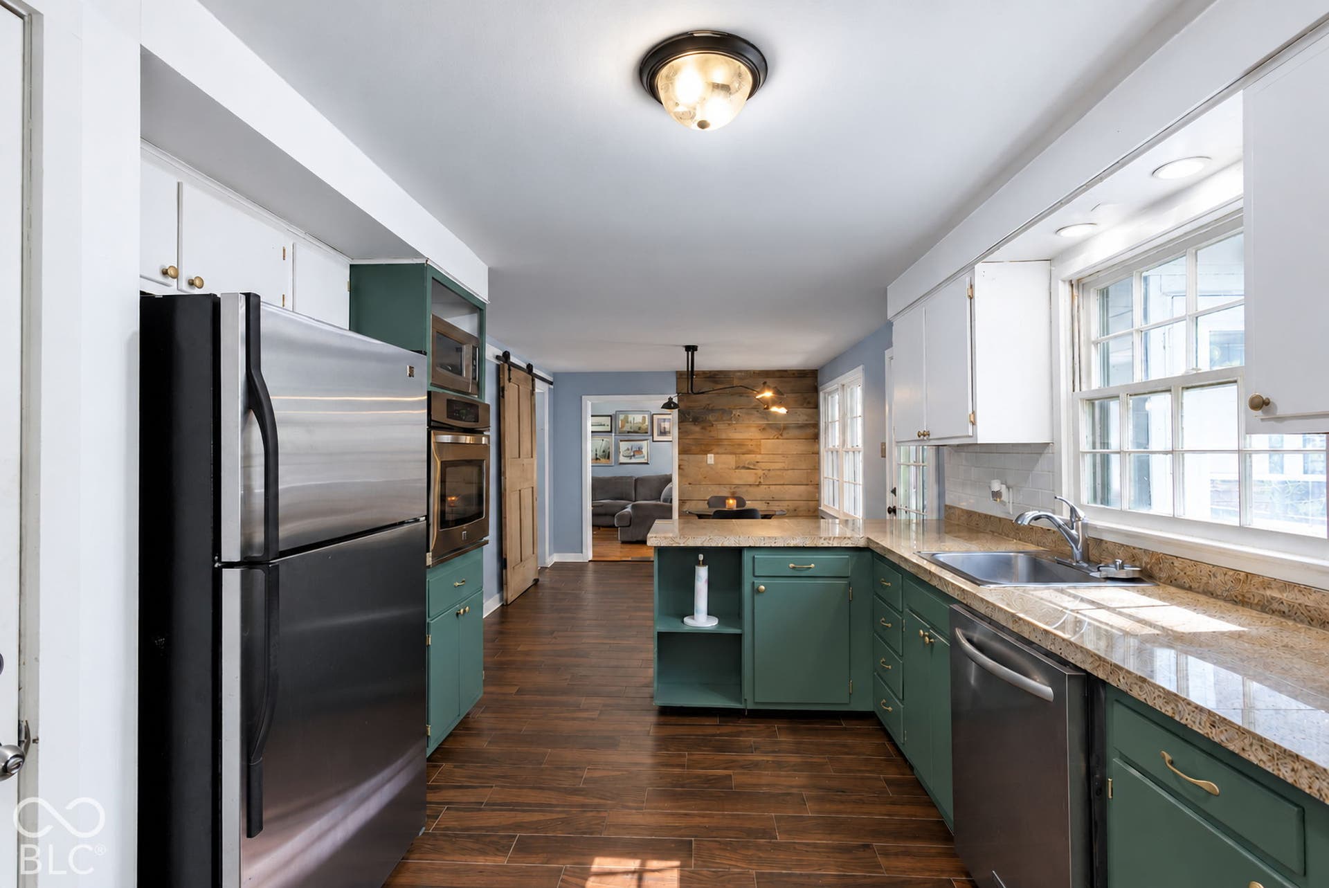 Kitchen featuring a stainless steel refrigerator, built-in double ovens, and a center island with a built-in cooktop