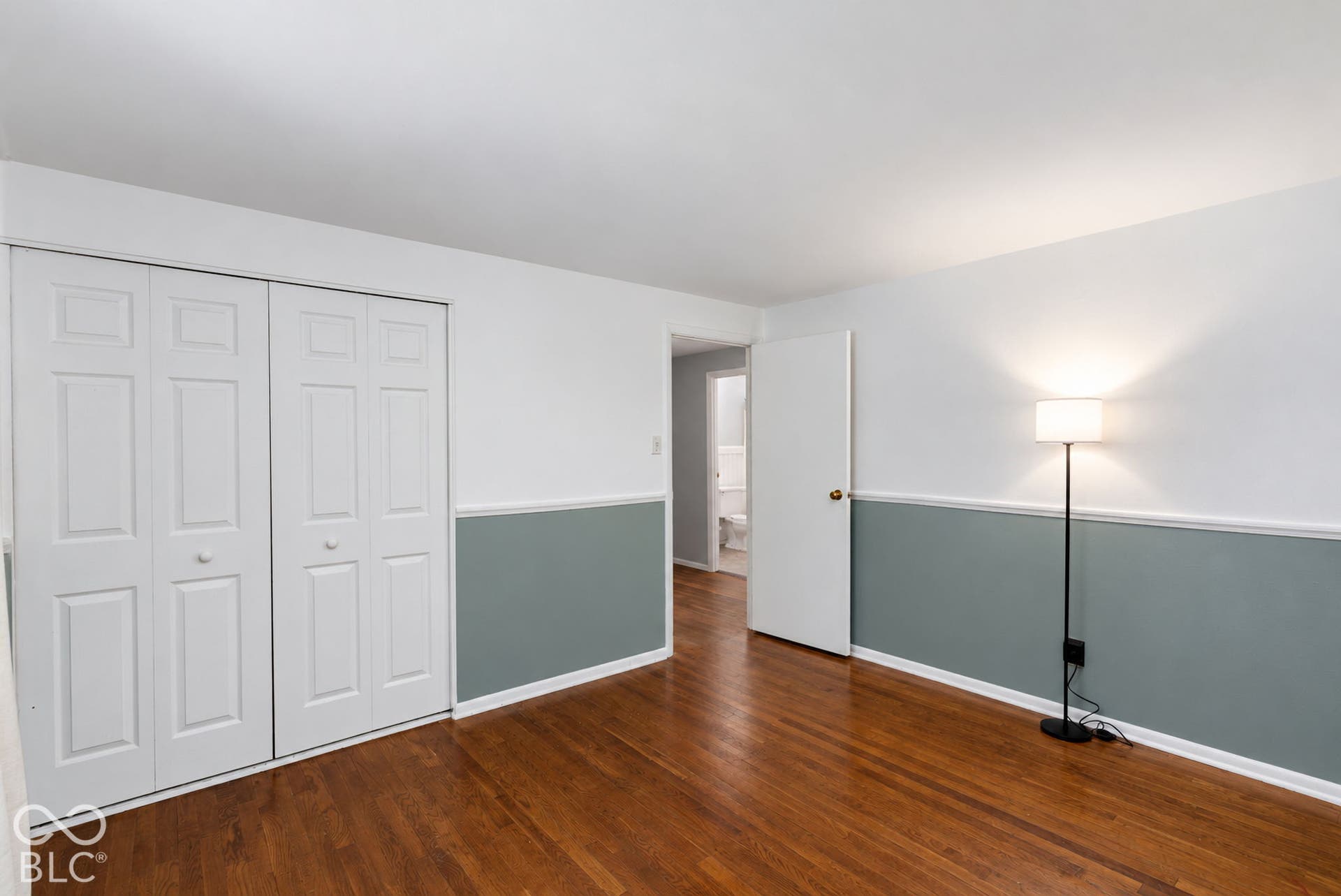 Hardwood flooring, painted walls with chair rail, and bifold closet doors
