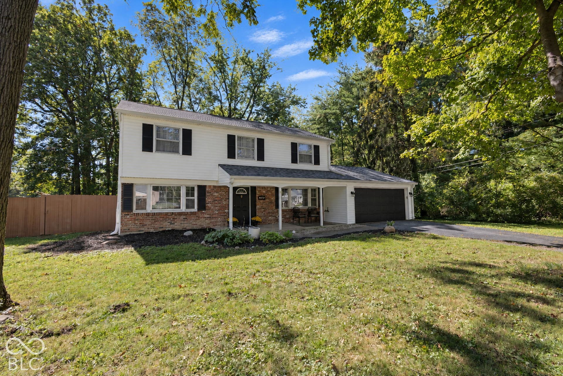 Two-story residence featuring white siding, brick accents, and a covered entry